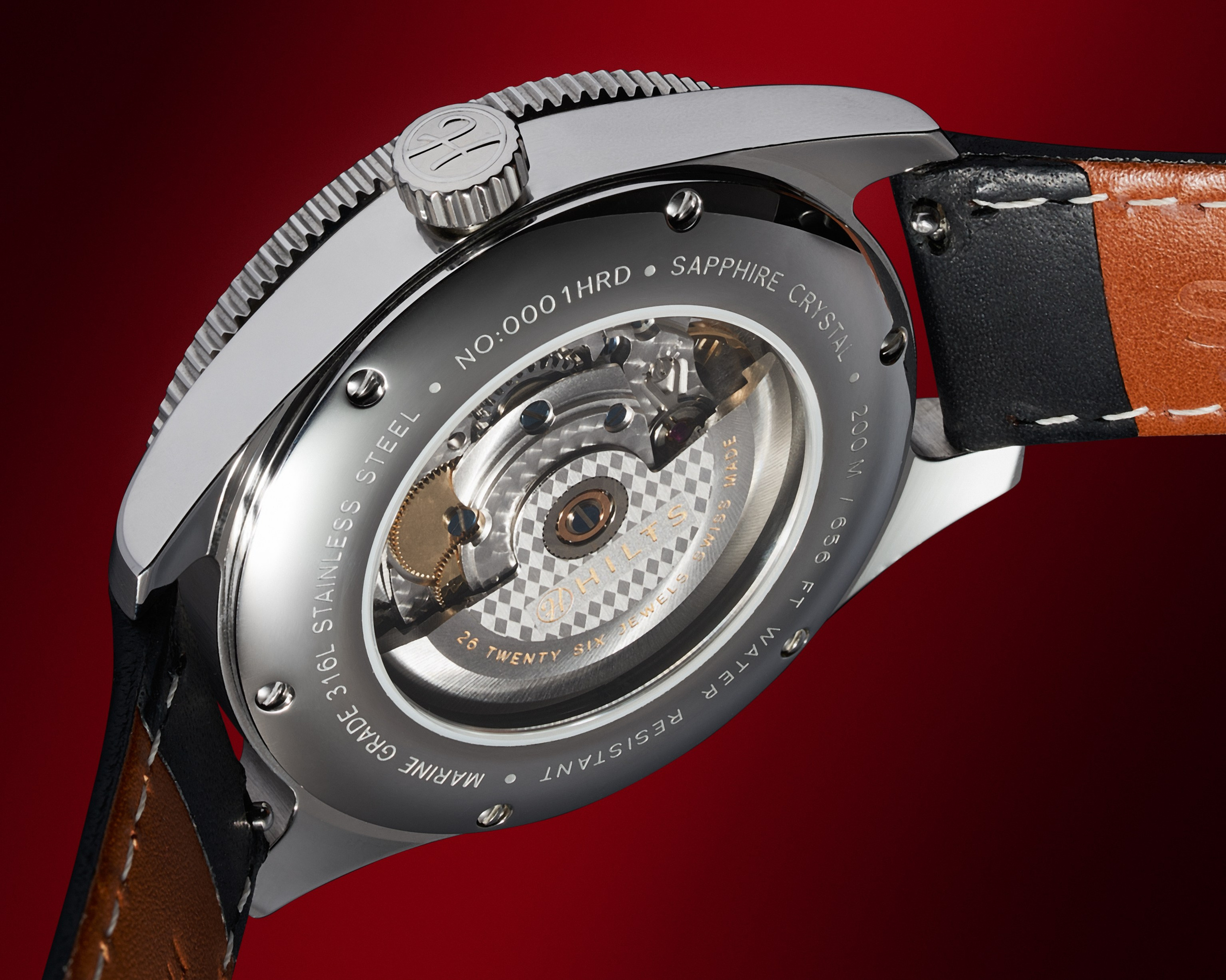 Watch automatic movement through the sapphire caseback, shot on a deep red background