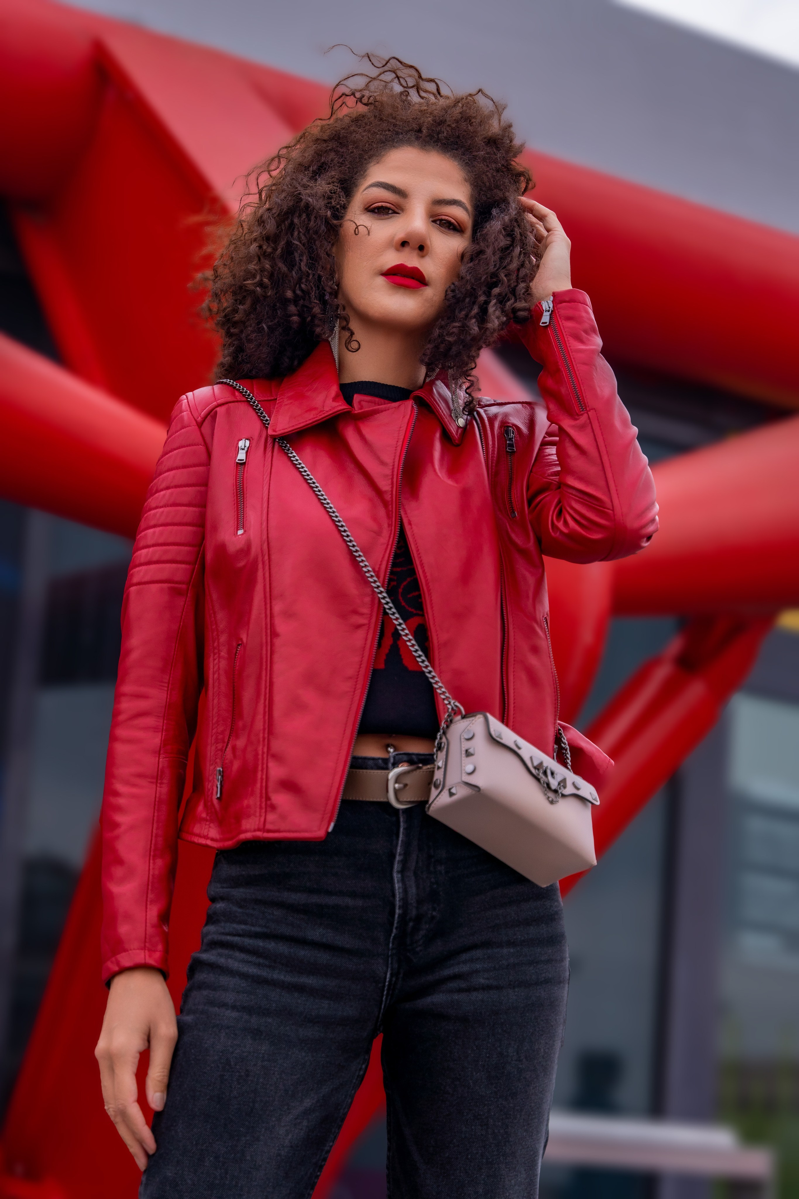 Modelo con chaqueta roja de piel, fondo urbano
