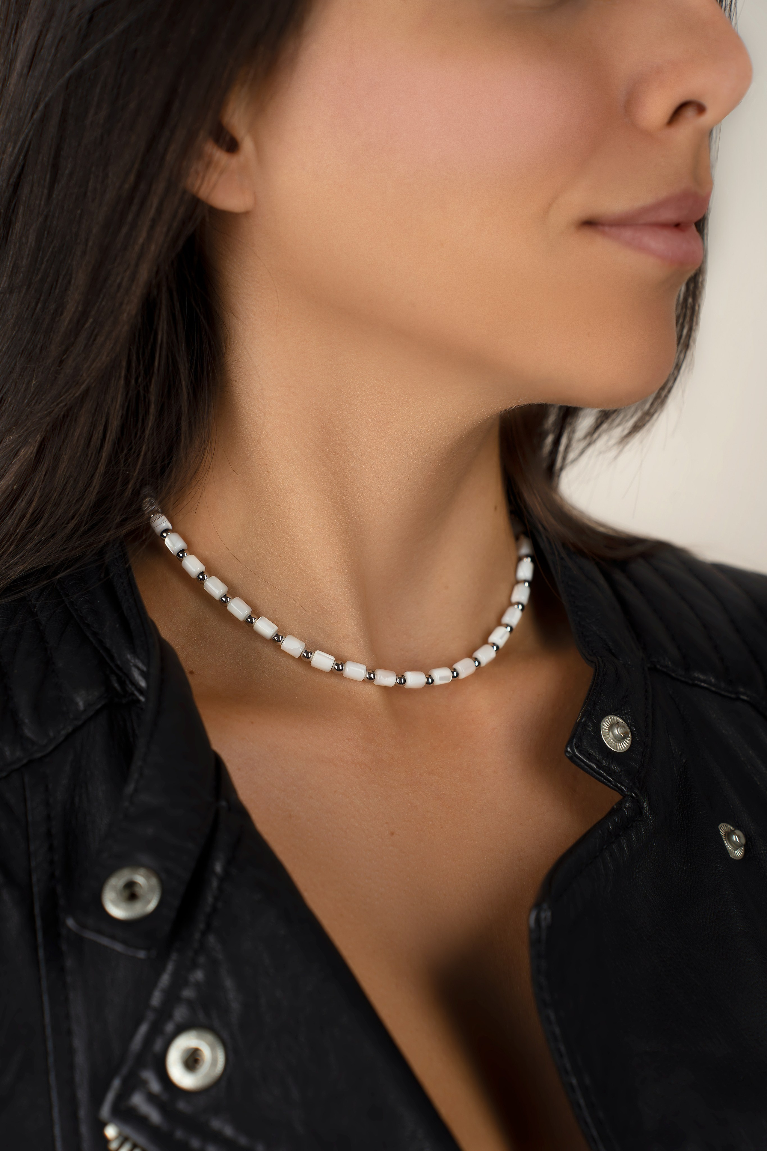 Collares dorados superpuestos sobre un top negro