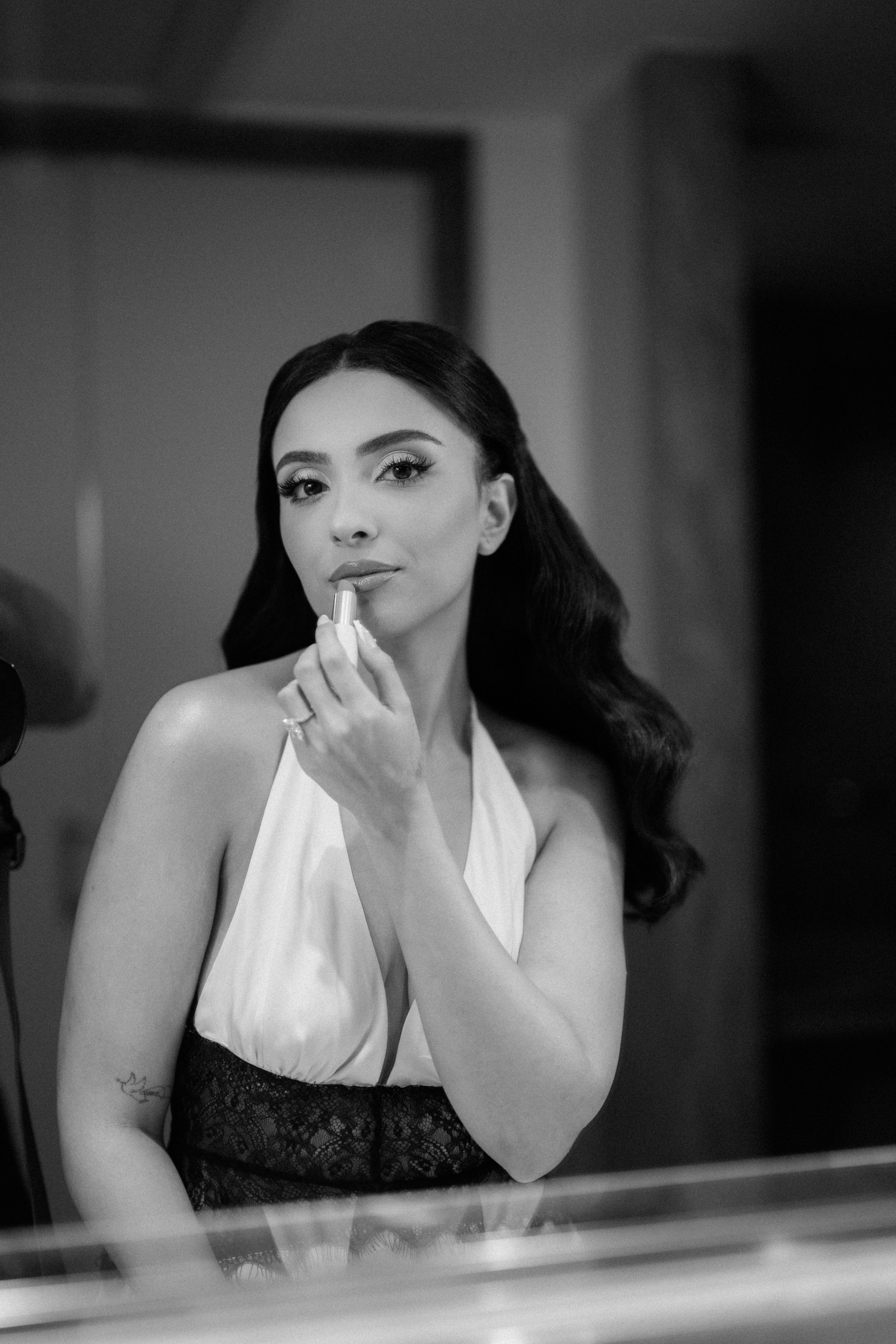Black and white portrait of bride adjusting her veil