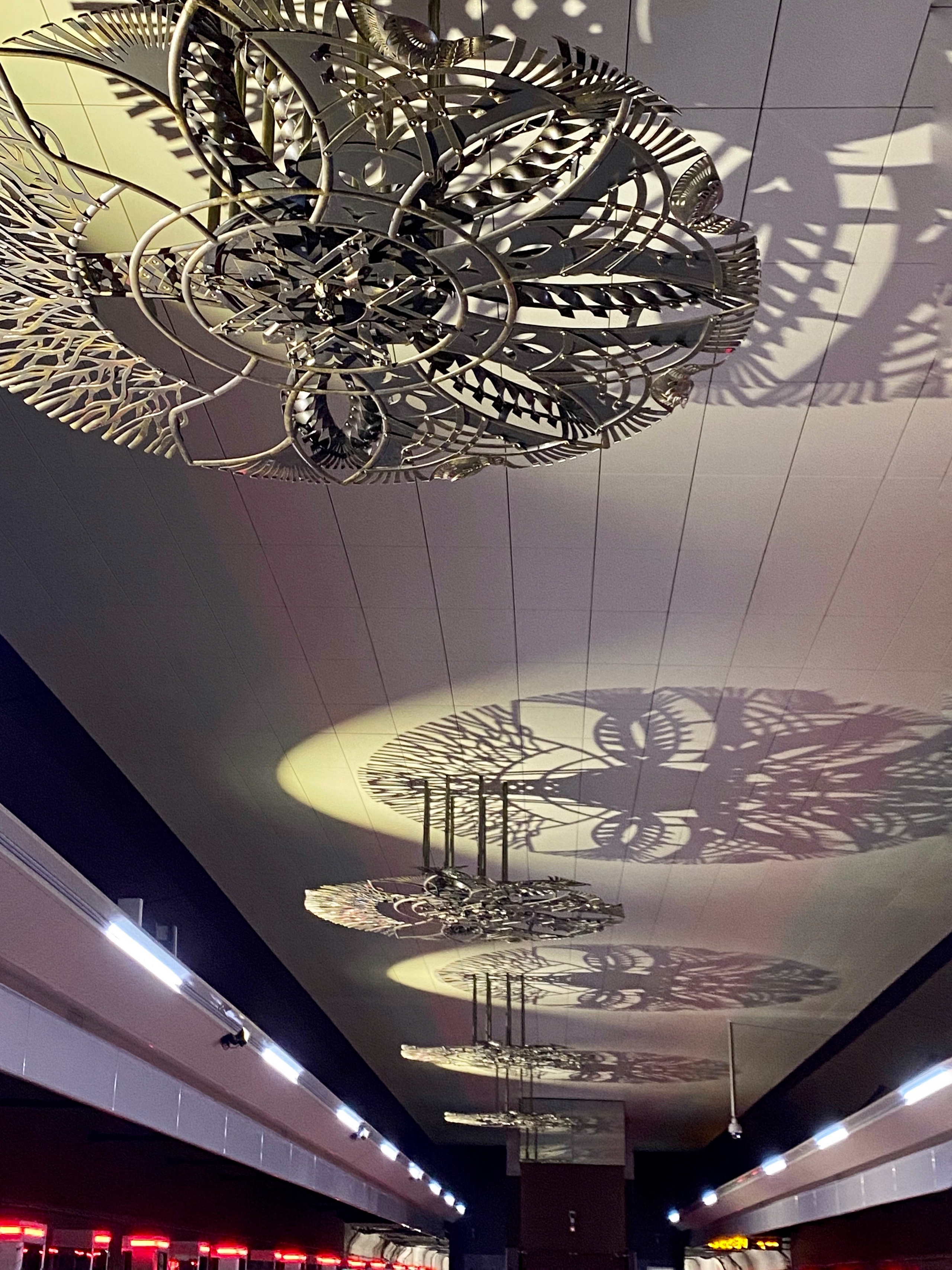 Минское Метро. Станция «Ковальская слобода». 2019-2020 «КАВАЛЬСКIЯ ВЫЦIНАНКI» кованые подвесные светотеневые композиции, декоративные элементы. Сталь, художественная ковка, лазерная резка, сварка. Художники Мария Тарлецкая, Павел Войницкий, Архитекторы Владимир Телепнёв, Ольга Телепнёва, Анна Кузмич. По мотивам произведений Елизаветы Червонцевой и Молодечненской школы вытинанки. Перонн. Перонный зал.