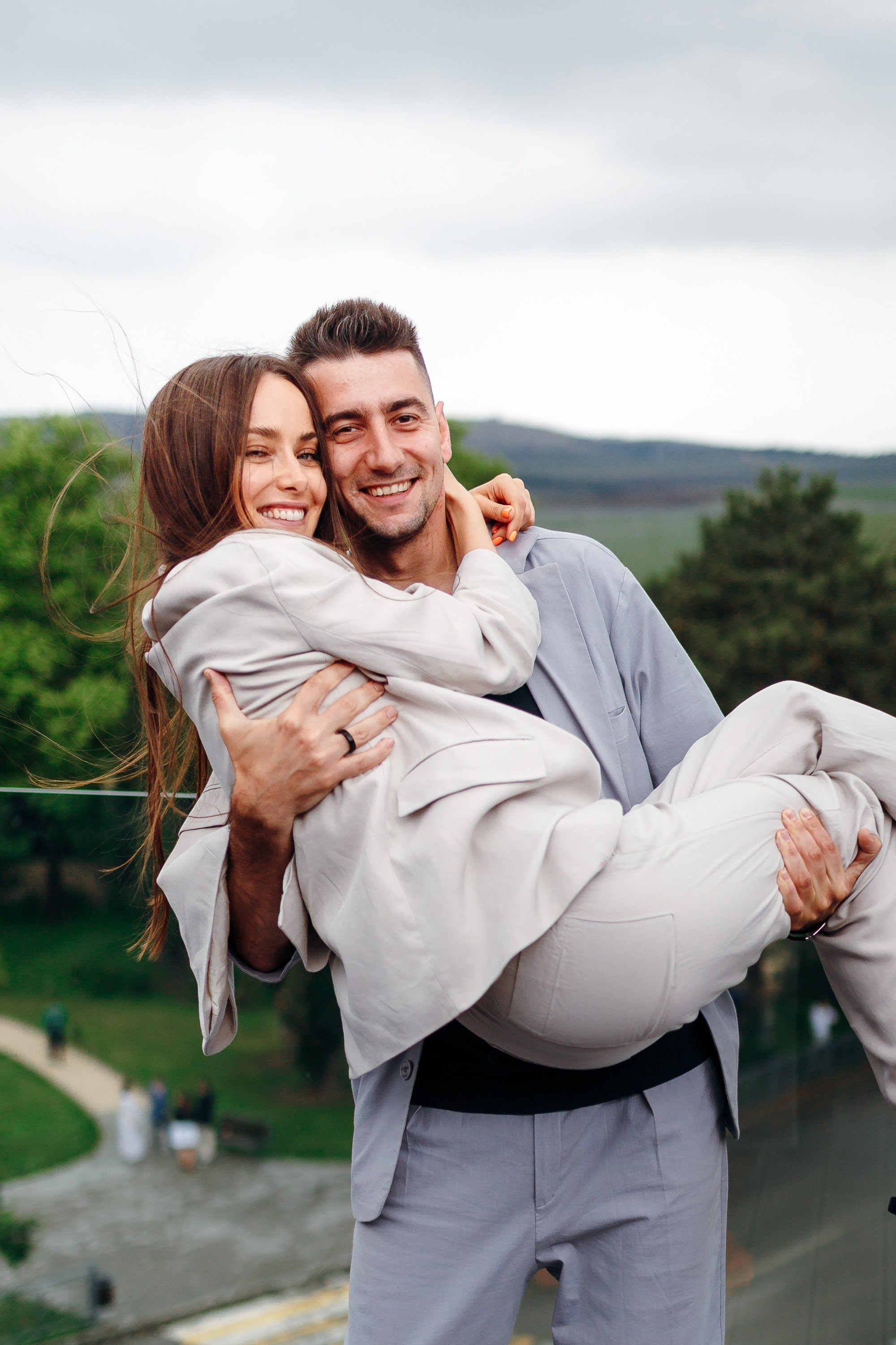 Man holding woman in arms, playful outdoor portrait