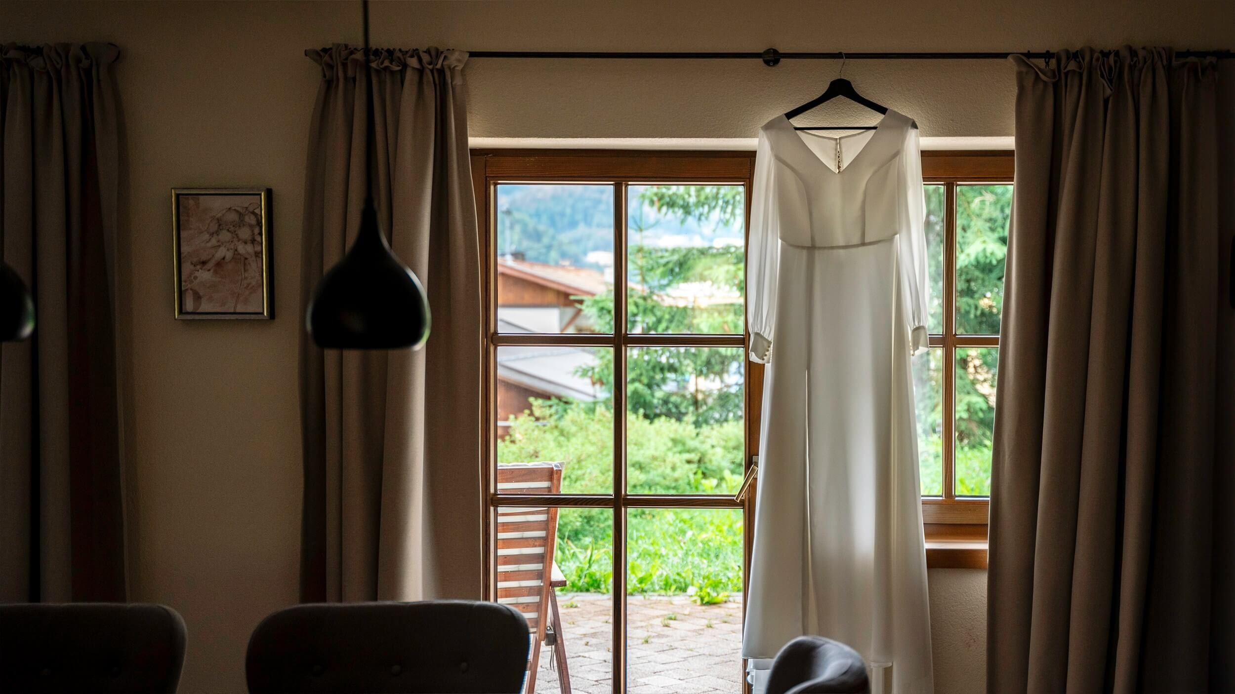 Brautkleid im Fenster eines Tiroler Chalets, bereit für die Hochzeit in Sölden.