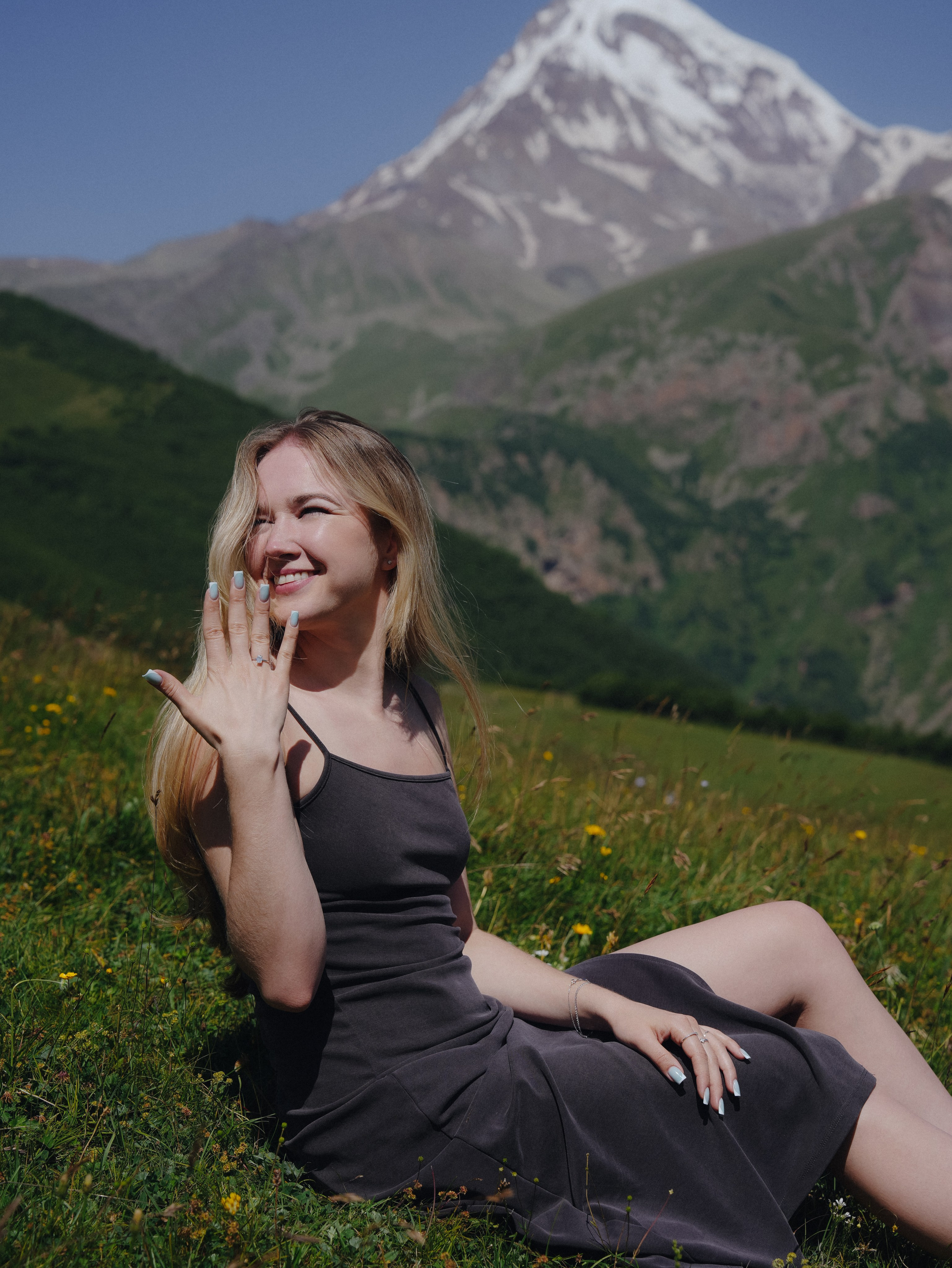 Woman sitting in wildflowers in Kazbegi mountains