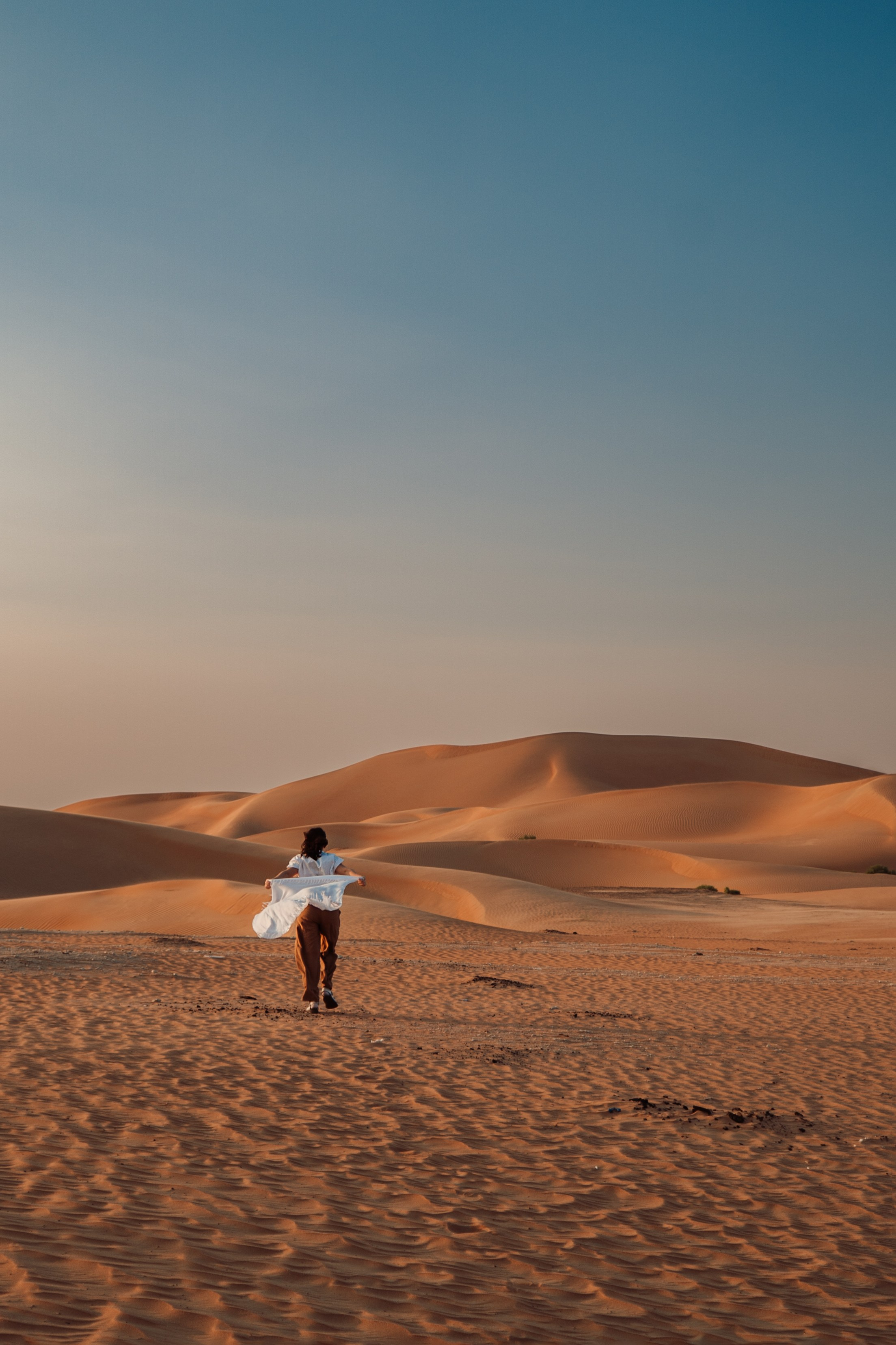 Photographer in the Abu Dhabi desert. Book a shoot in the Dubai desert, UAE. Romance of the East. The endless desert of the Emirates. Photos in the desert. Minimalism in photography. Nice photo sessions in the desert. Girl in the desert