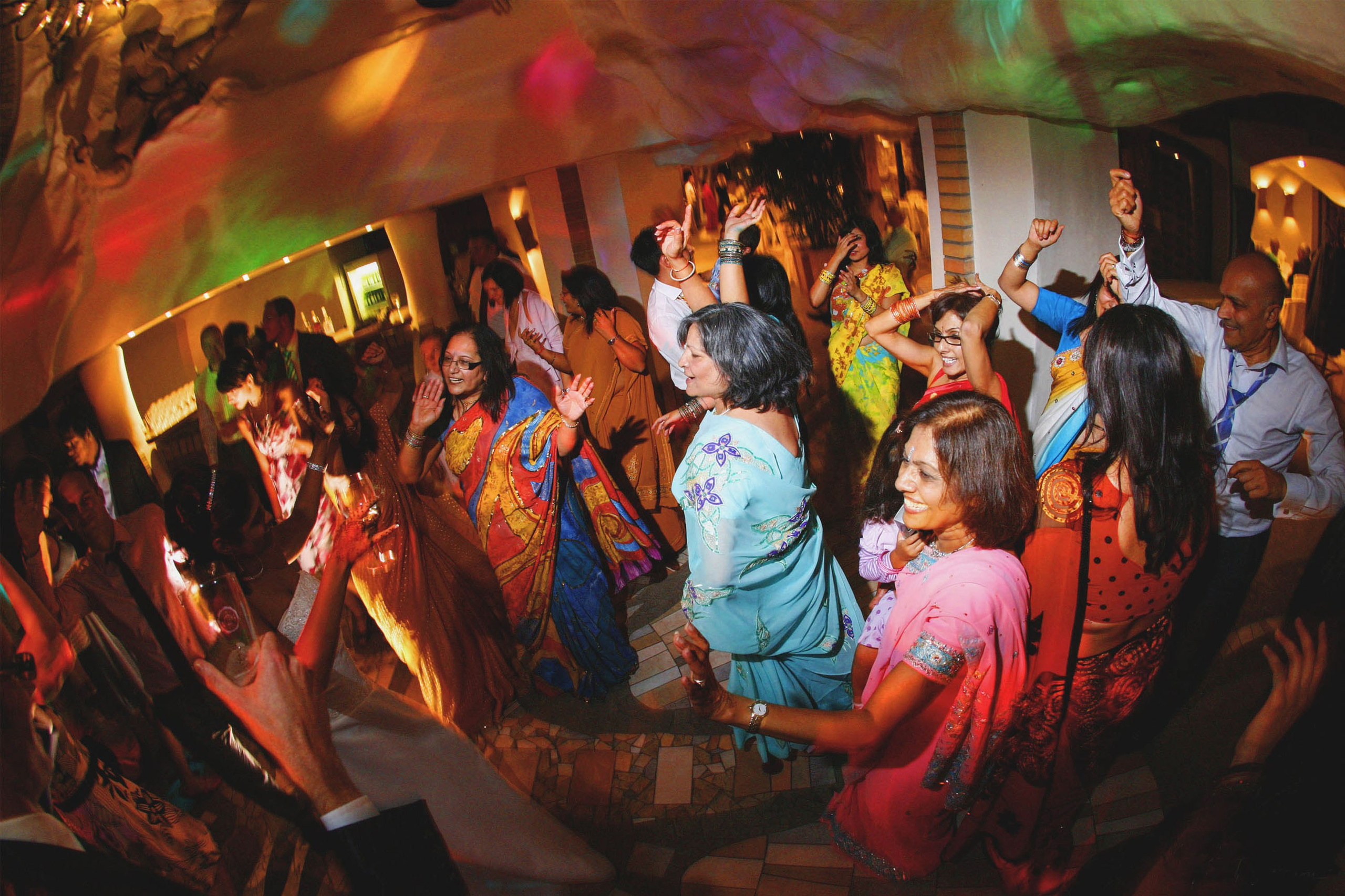 Bride and groom with Indian wedding guests dancing to Bollywood music at Chateau Stirin
