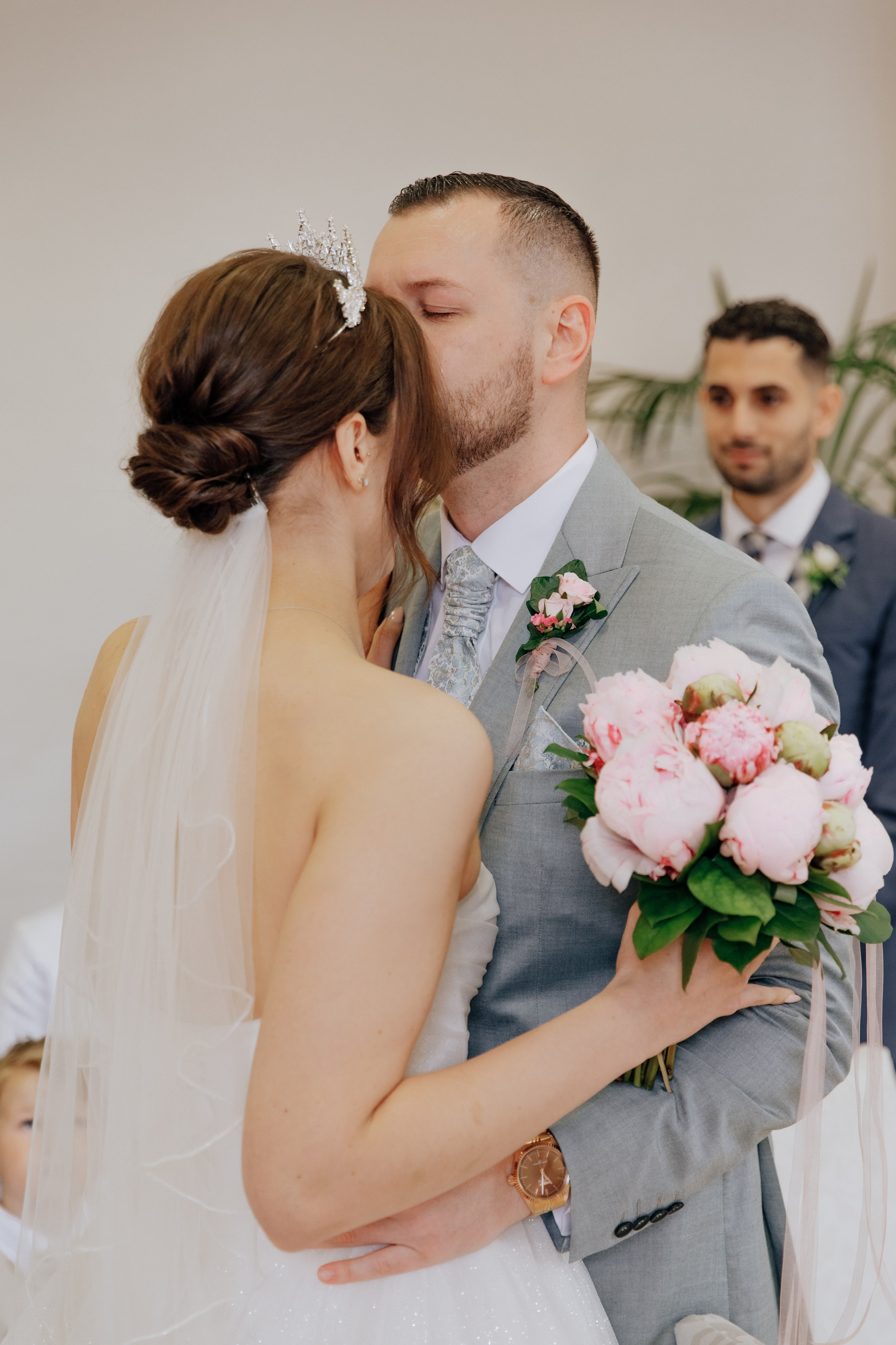 Der Bräutigam küsst die Braut auf die Stirn. Ein liebevoller und intimer Moment der Hochzeit.