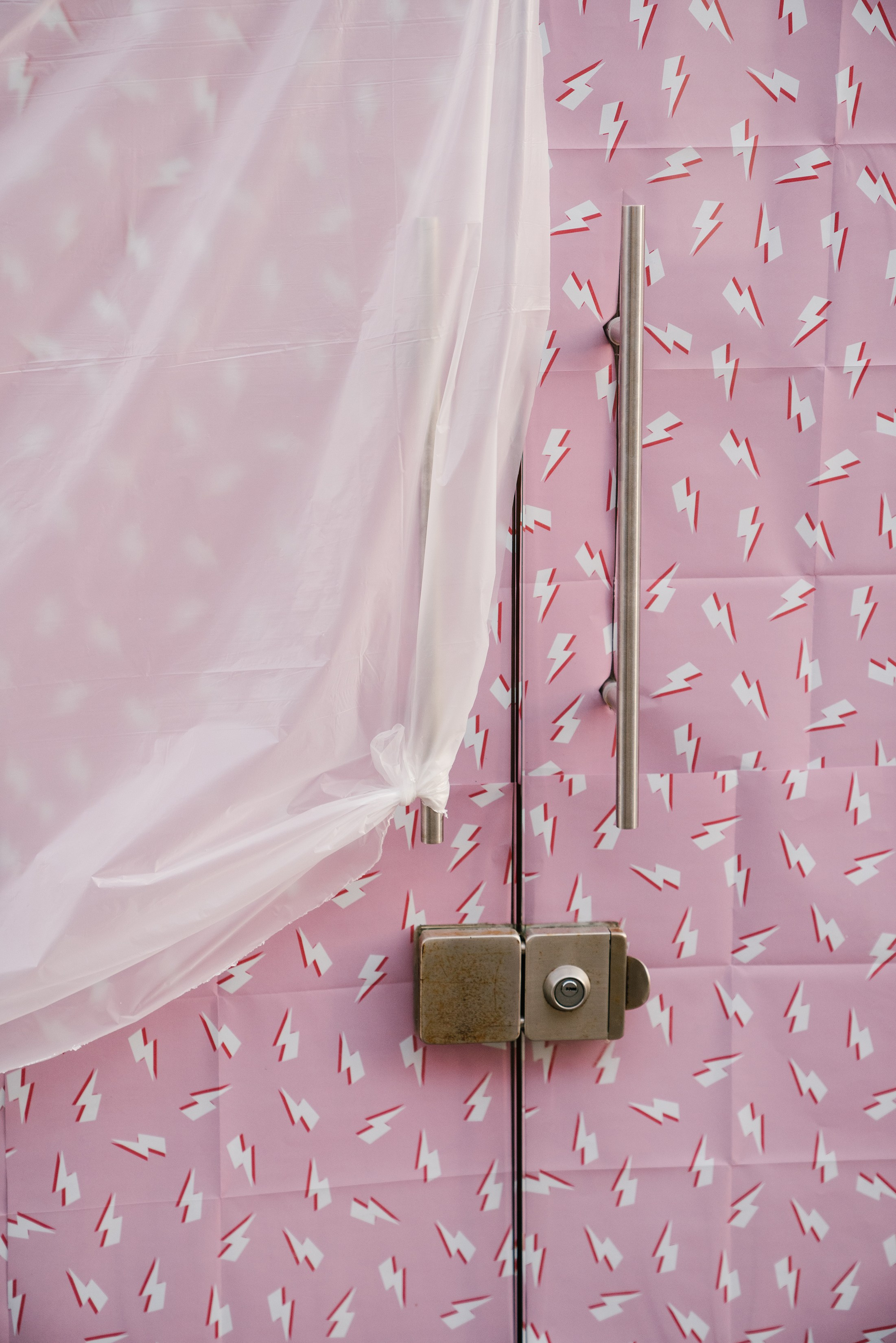 Kunst Compositing von Plastik, das auf eine rosa Tür mit einem Schließfach fällt