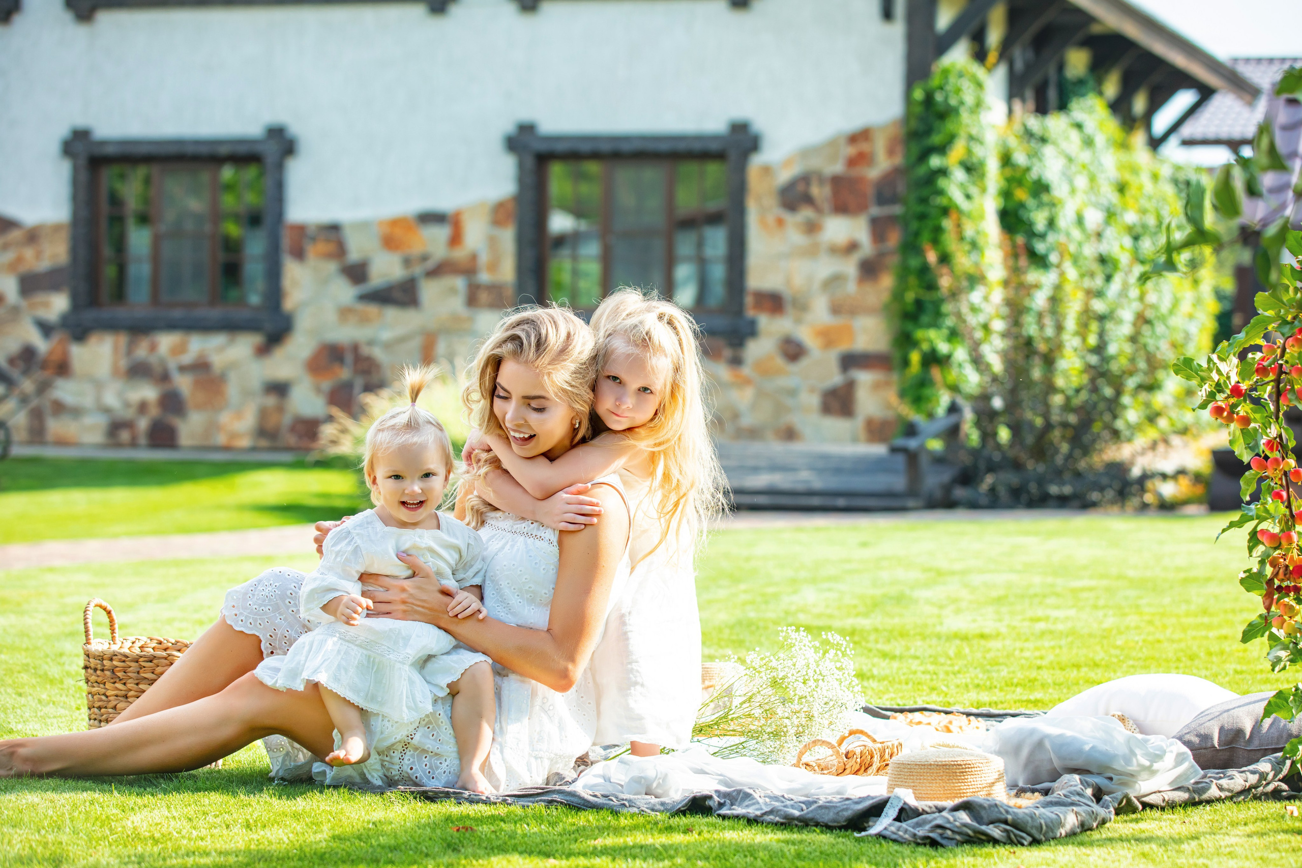 Portrait familial champêtre avec maman et ses filles, moment complice dans le jardin