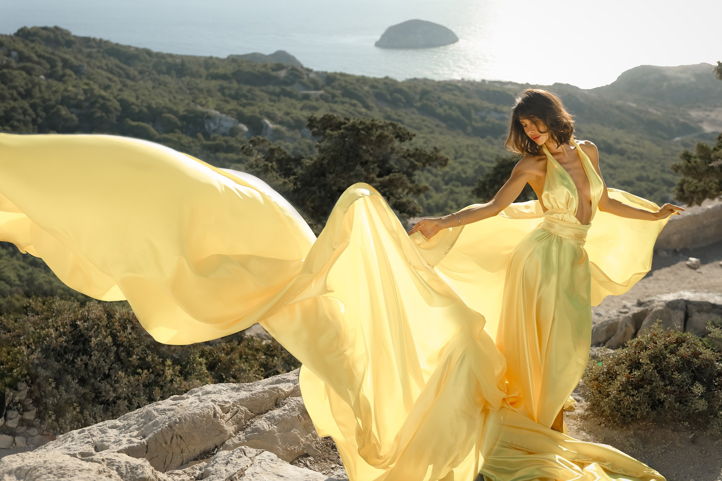 An art photo shoot of a girl in a flying dress in Monolithos castle in Rhodes, Greece