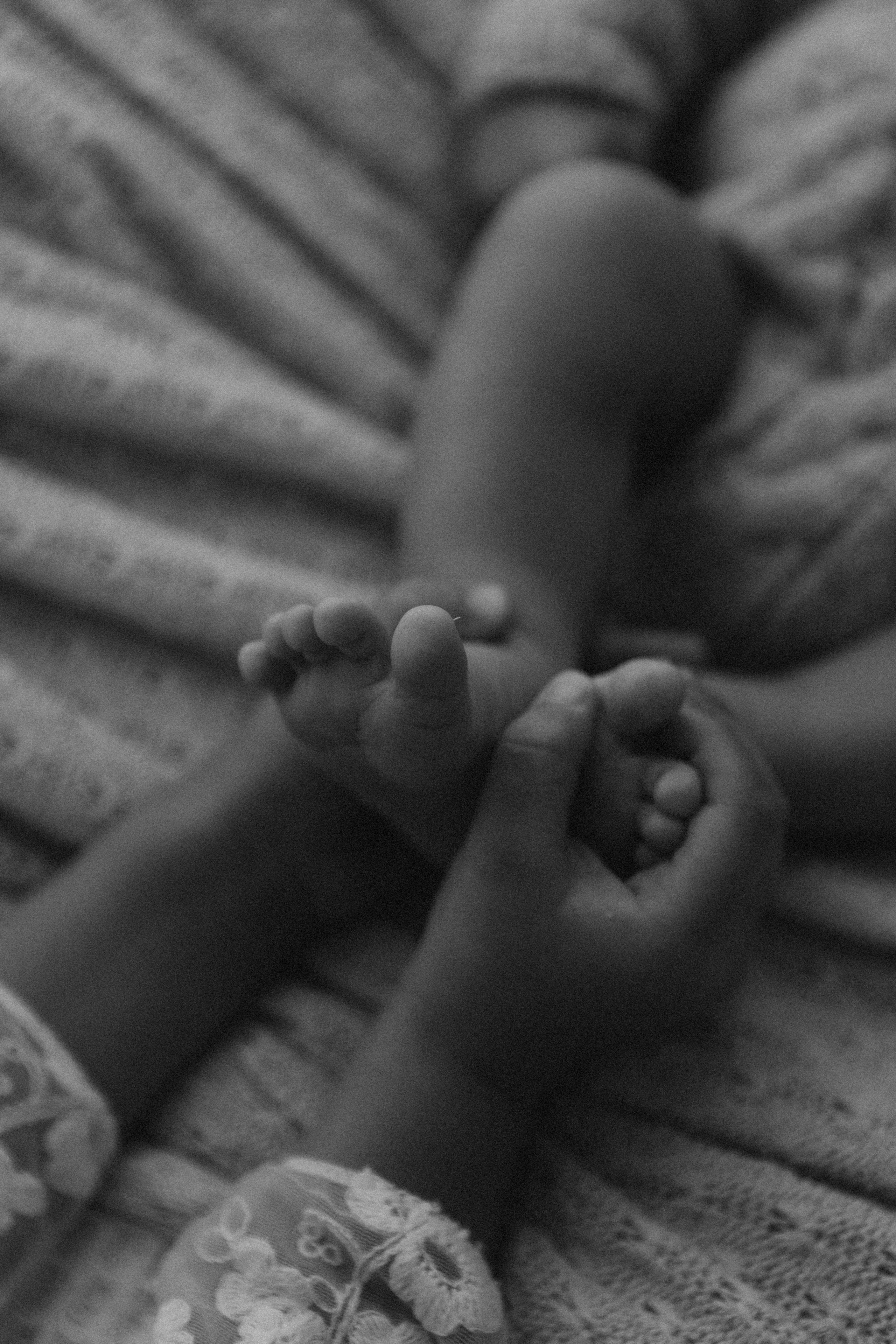 irmã mais velha segurando os pés do recém-nascido em ensaio newborn em Sorocaba