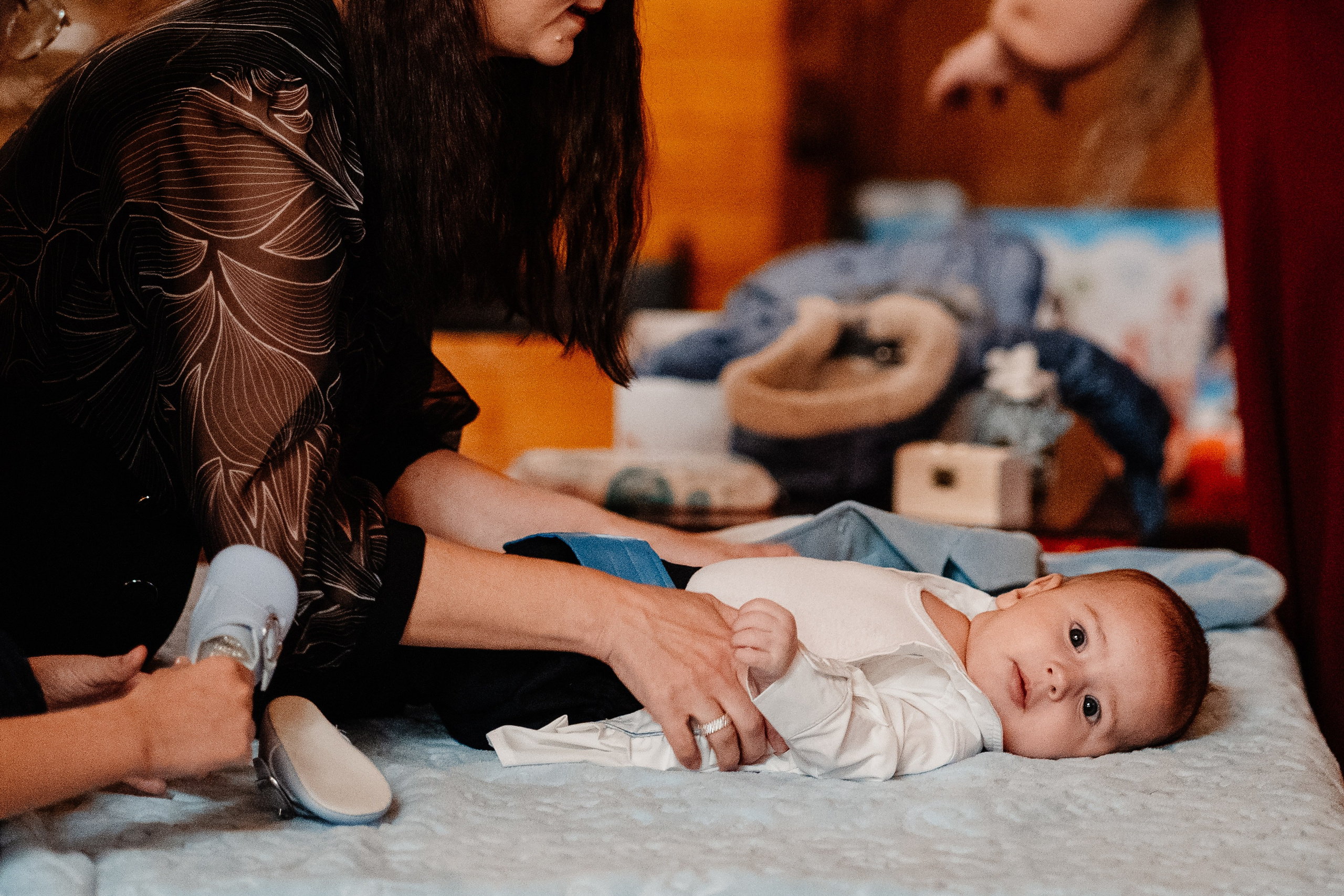 Instantaneu plin de tandrețe dintre părinți și bebeluș în ziua botezului, realizat în Bucuresti. Fotografie profesională de botez, capturând emoțiile autentice ale familiei într-un decor luminos și cald