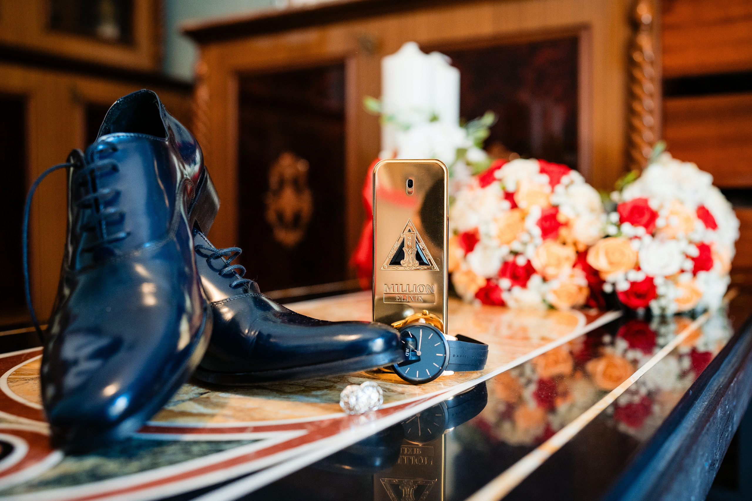 Detalii cu verighetele, parfumul și invitațiile pe o masă elegantă