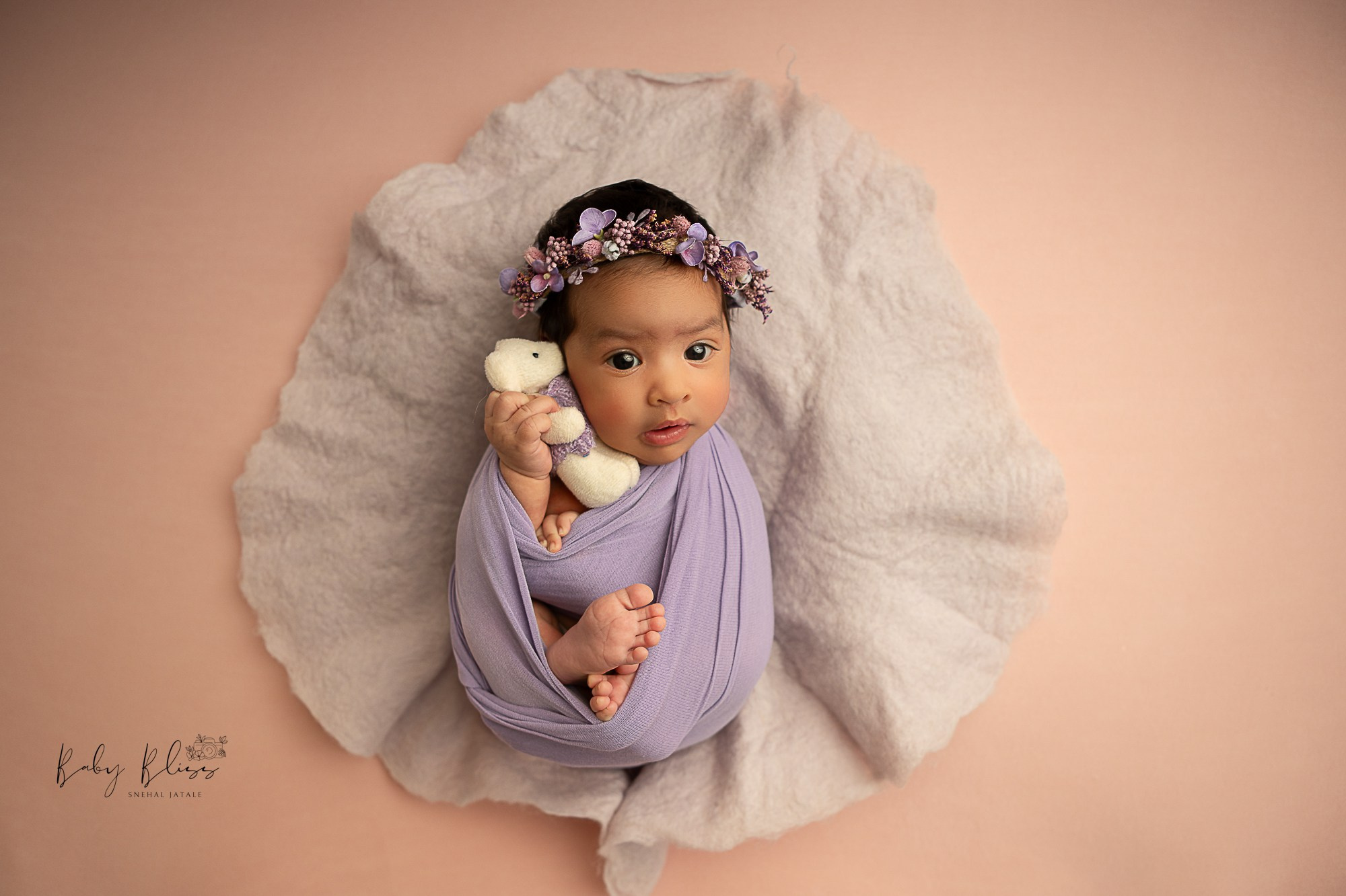 little toy in newborn baby's hand wrapped in beautiful lavender colour.