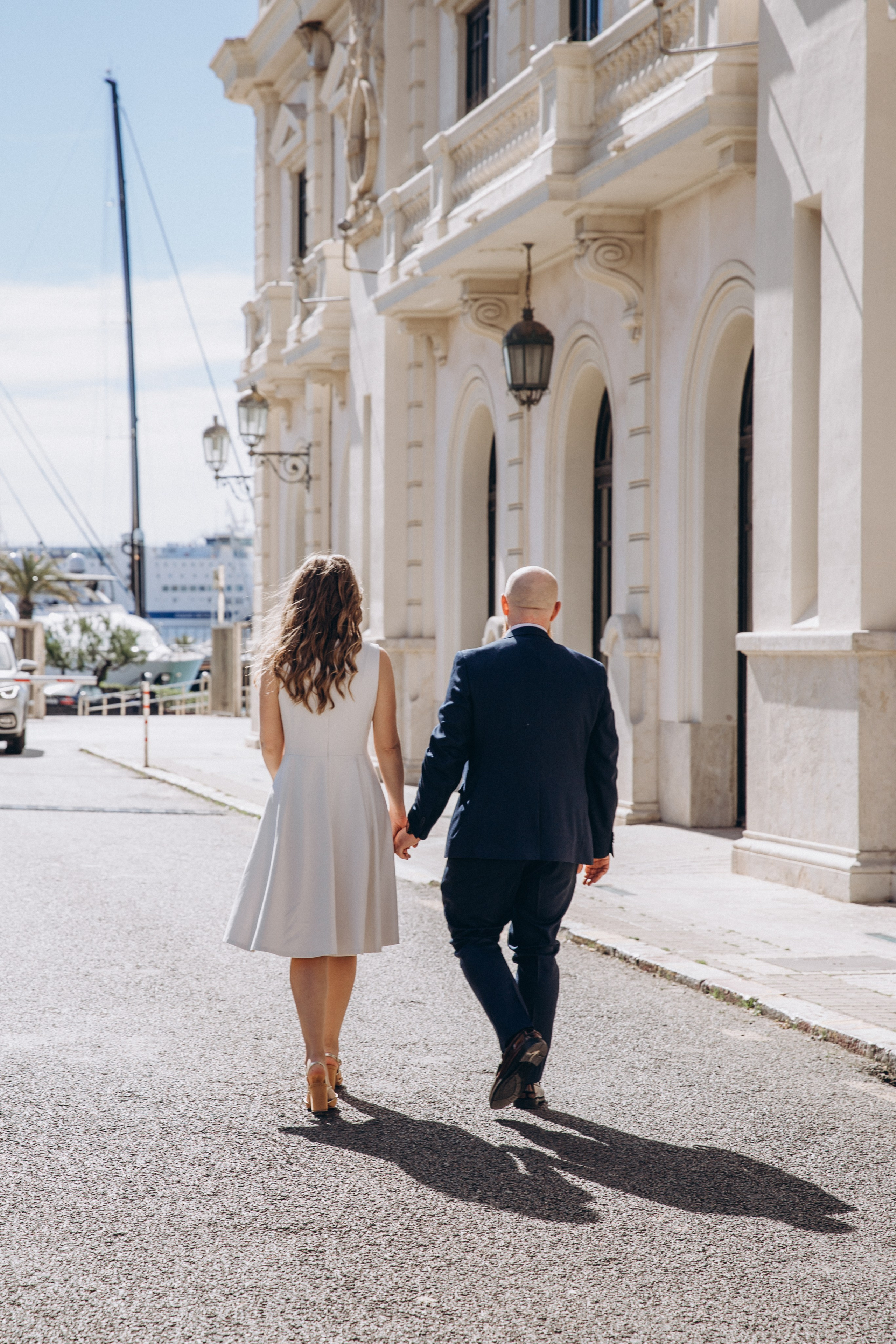 Bride and groom walk hand in hand through the historic streets of València after their city hall civil wedding. The natural documentary-style photography highlights the charm of an intimate urban wedding in Spain.