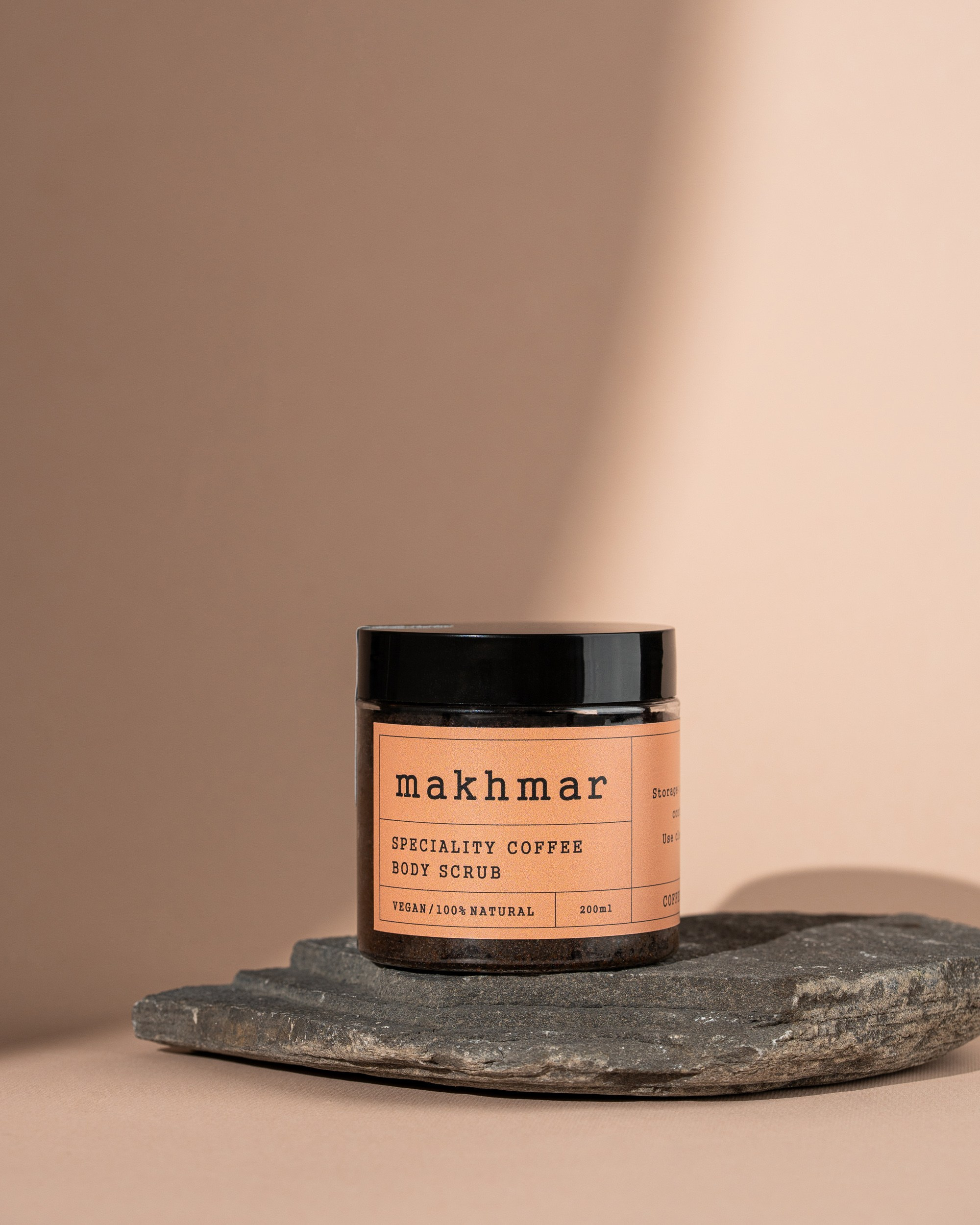 Bej fon və qara daş üzərində minimalist formada çəkilmiş Makhmar qəhvə skrabı məhsulu