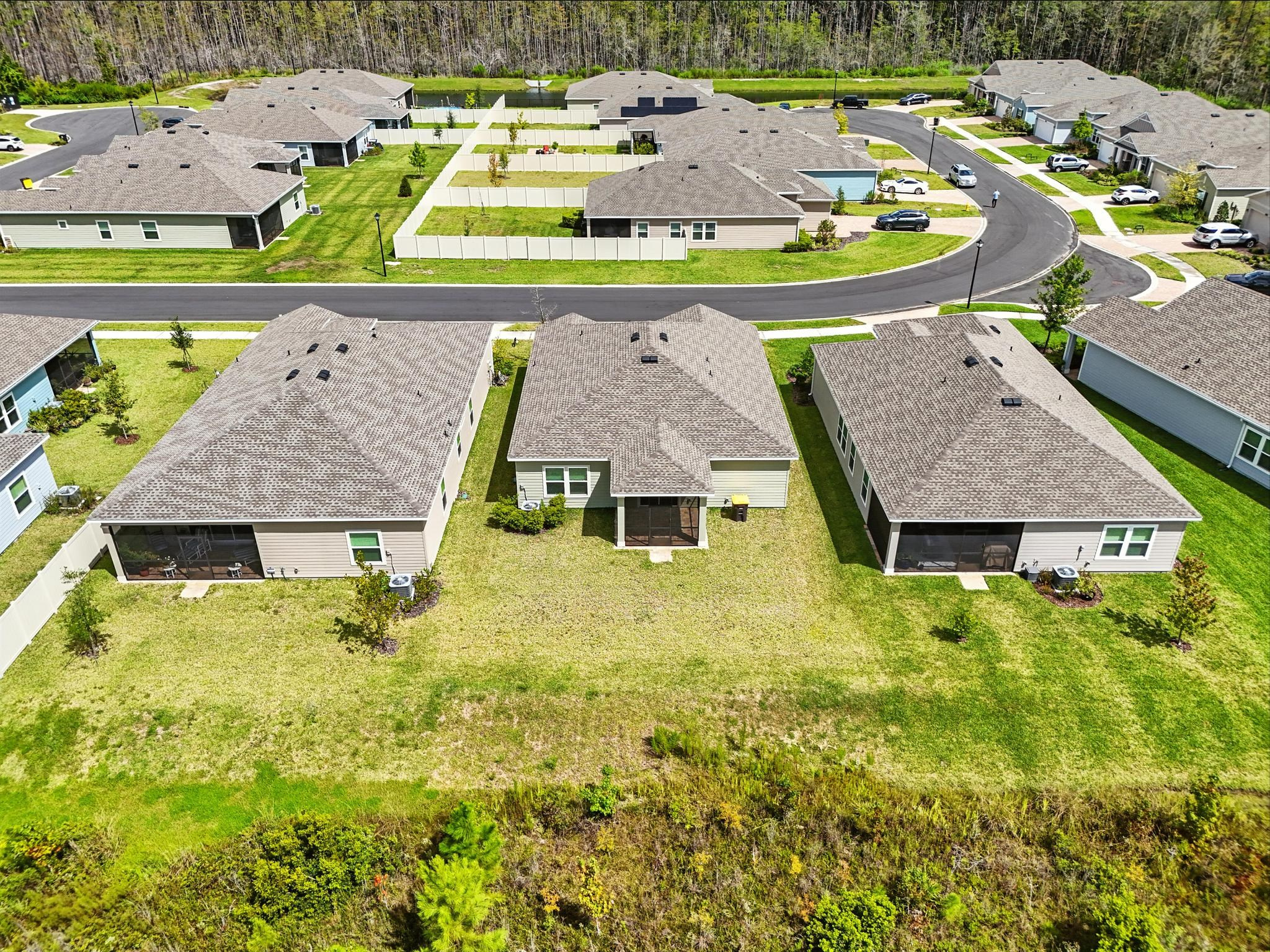 Modern single-family houses with fenced backyards, aerial view