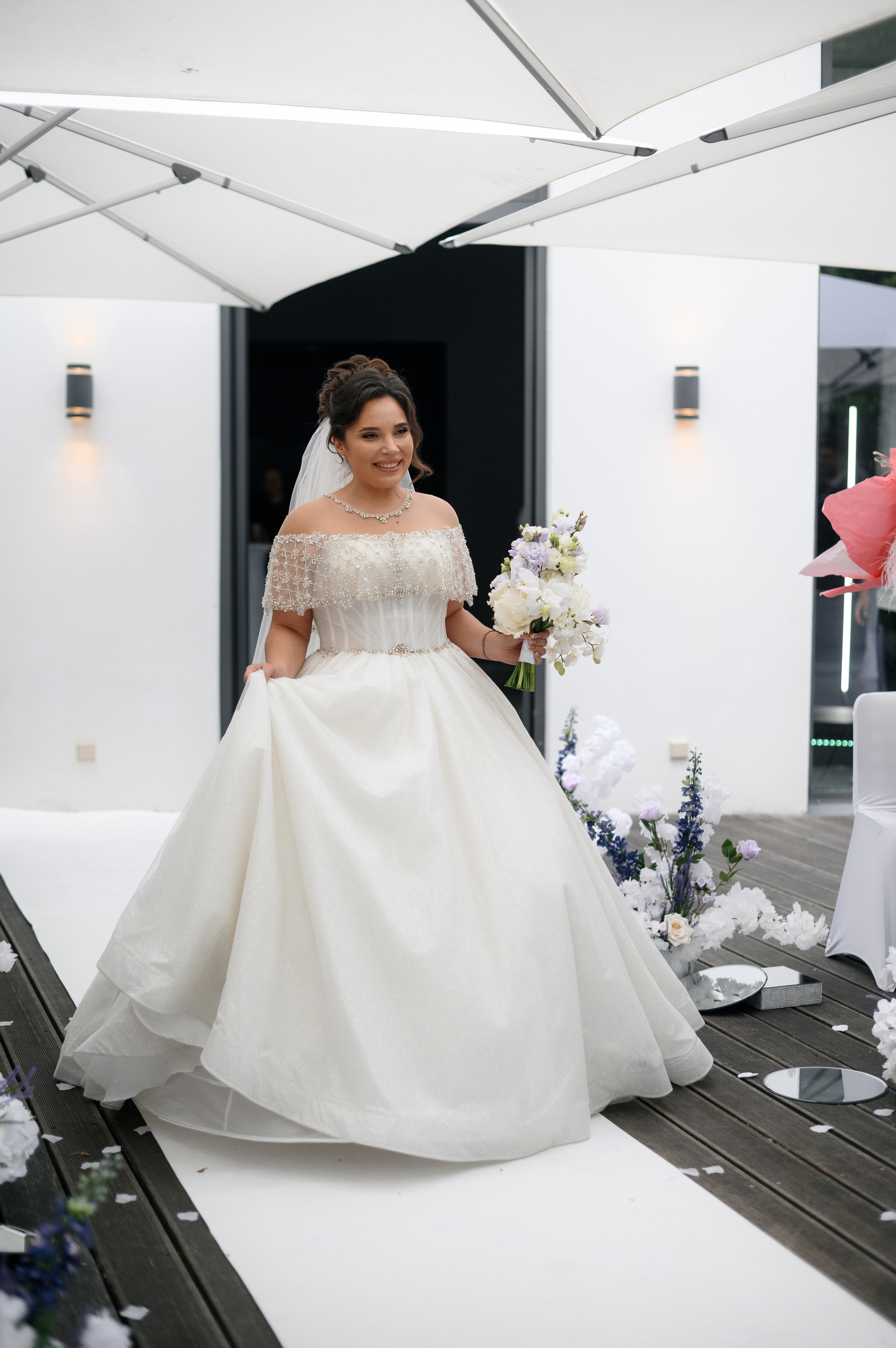 Braut geht im Brautkleid zur Trauung im Freien