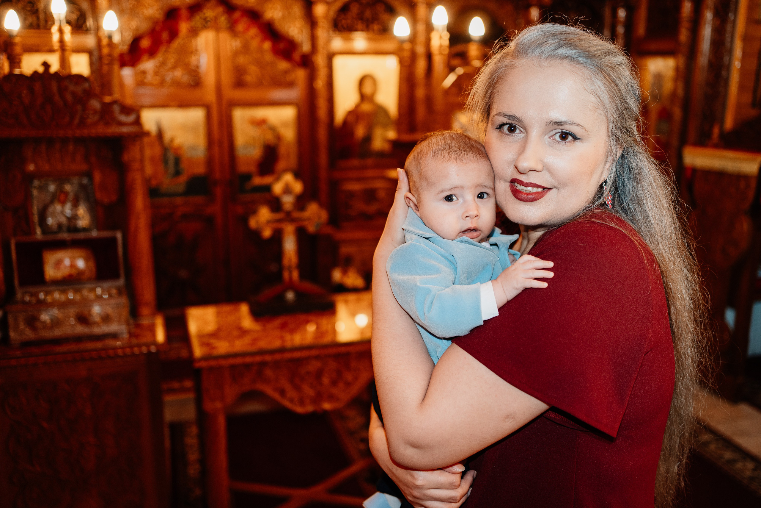 Instantaneu plin de tandrețe dintre părinți și bebeluș în ziua botezului, realizat în Bucuresti. Fotografie profesională de botez, capturând emoțiile autentice ale familiei într-un decor luminos și cald