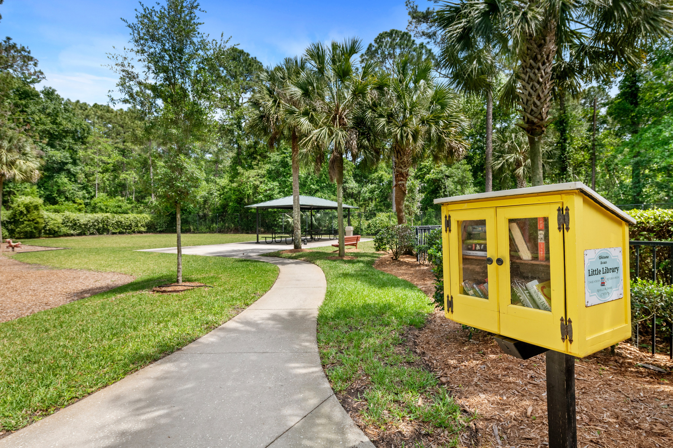 Little Free Library and picnic pavilion in a shaded park area