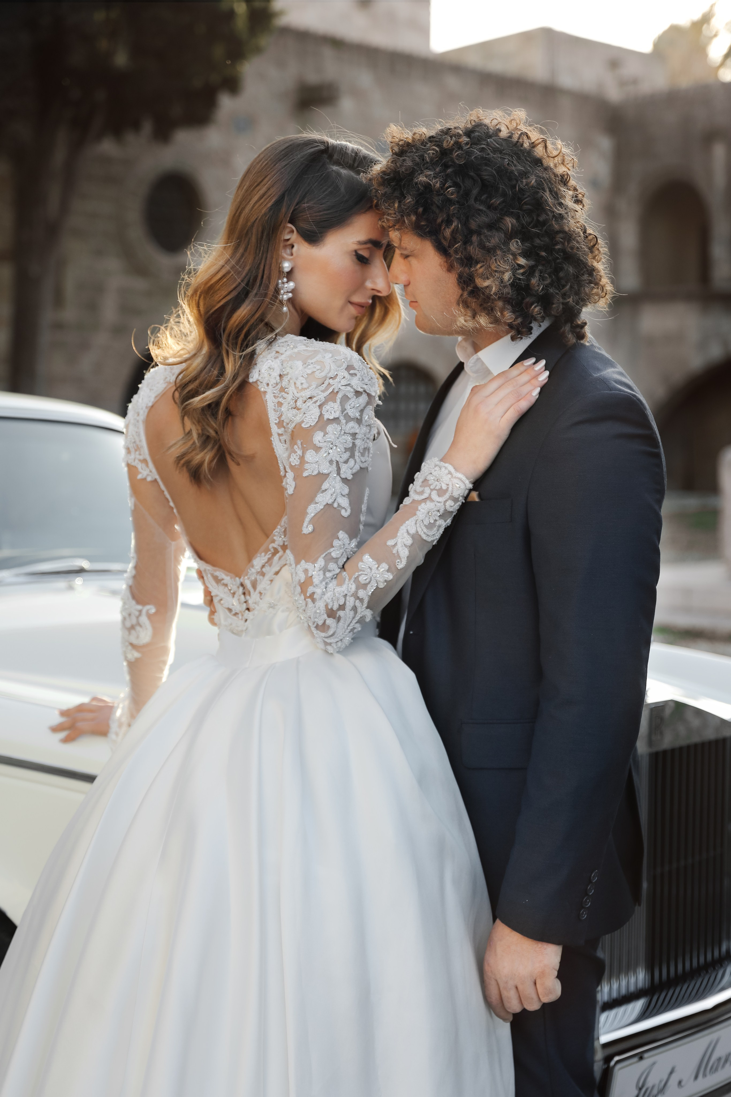 A bride and groom next to Rolls Royce in old town of Rhodes island, Greece