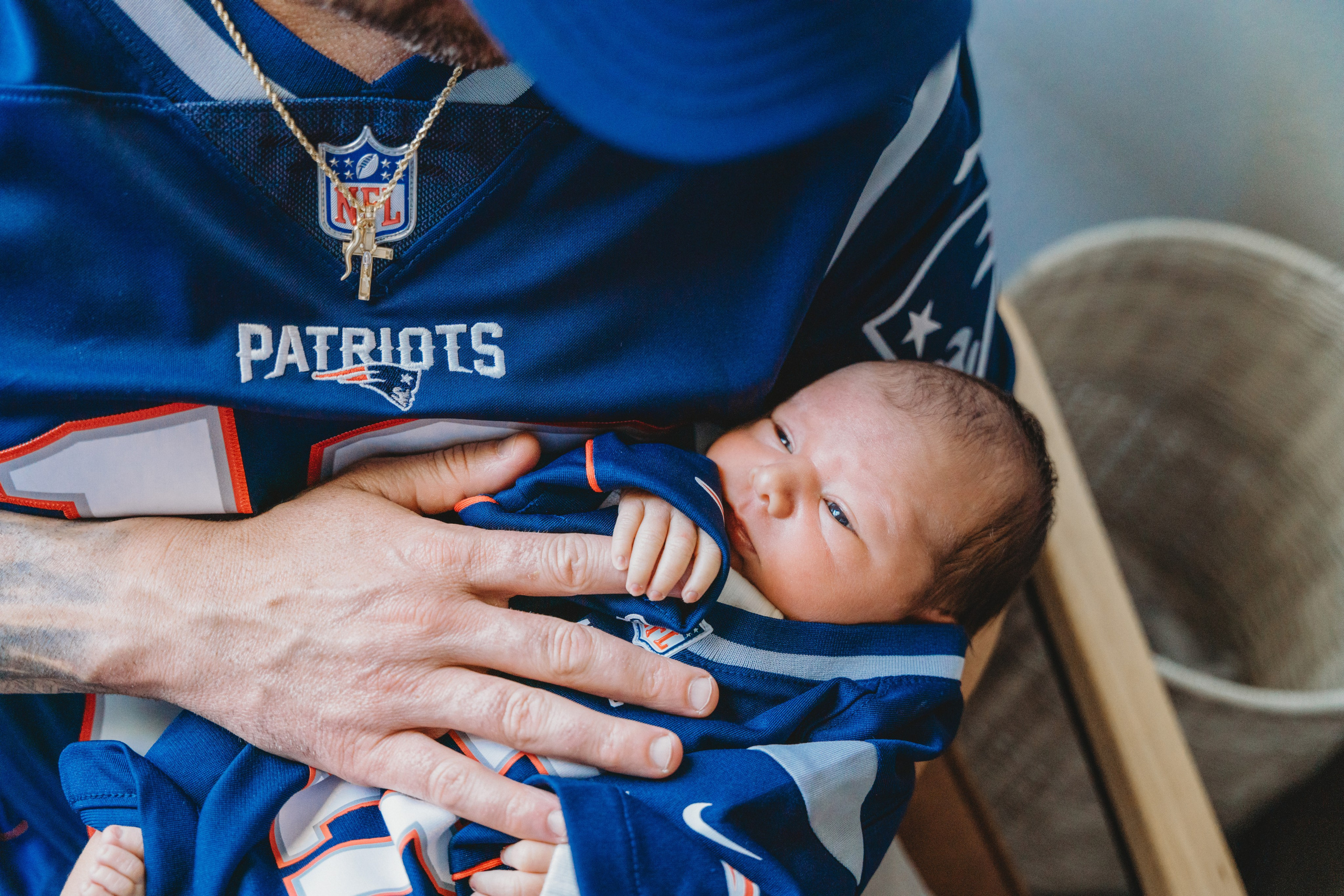 Portrait of baby holding fathers finger