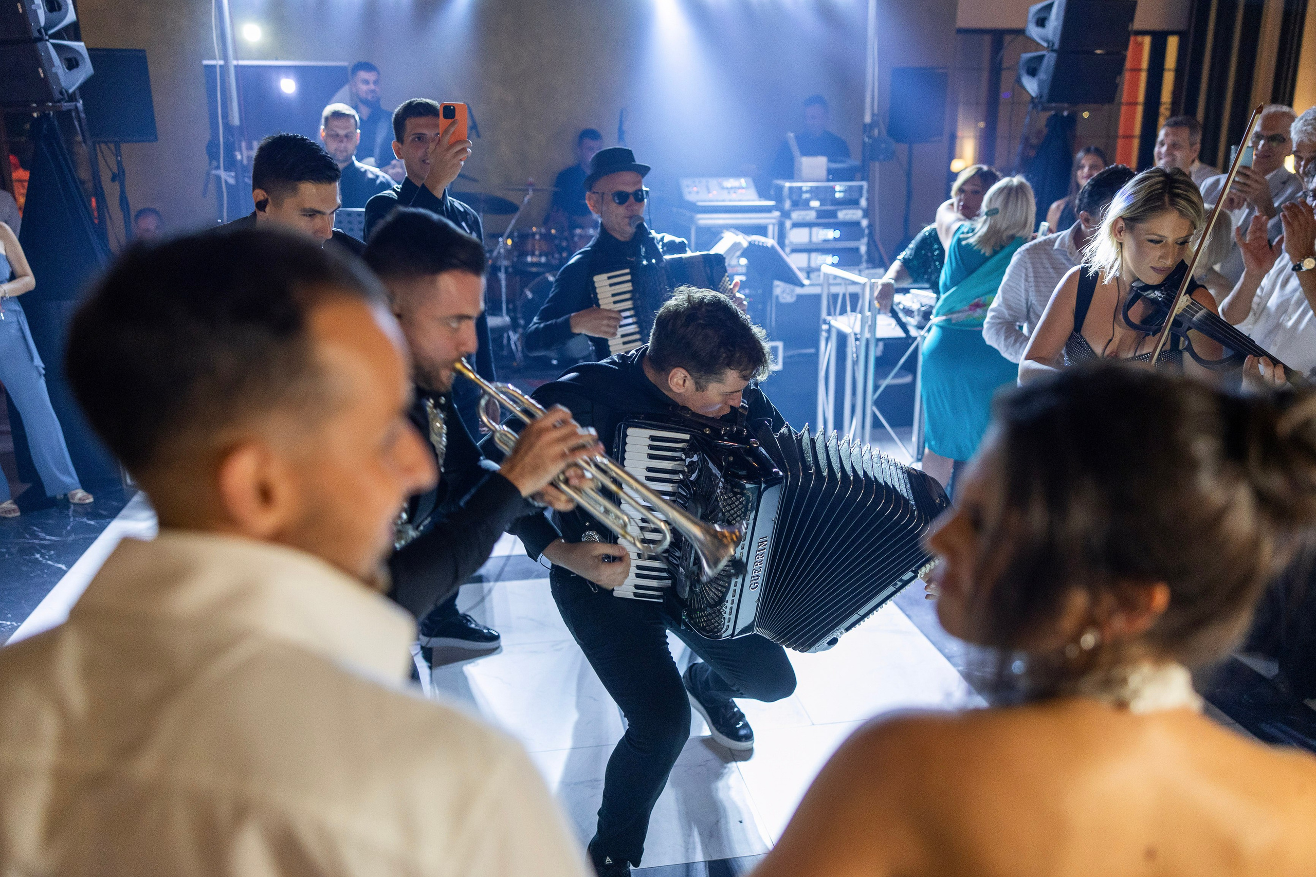 mladenci gledaju i slusaju harmonikasa na njihovoj svadbi