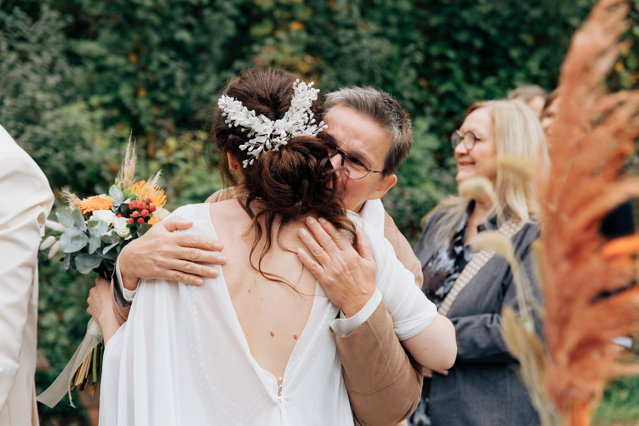 Die Mutter umarmt die Braut.