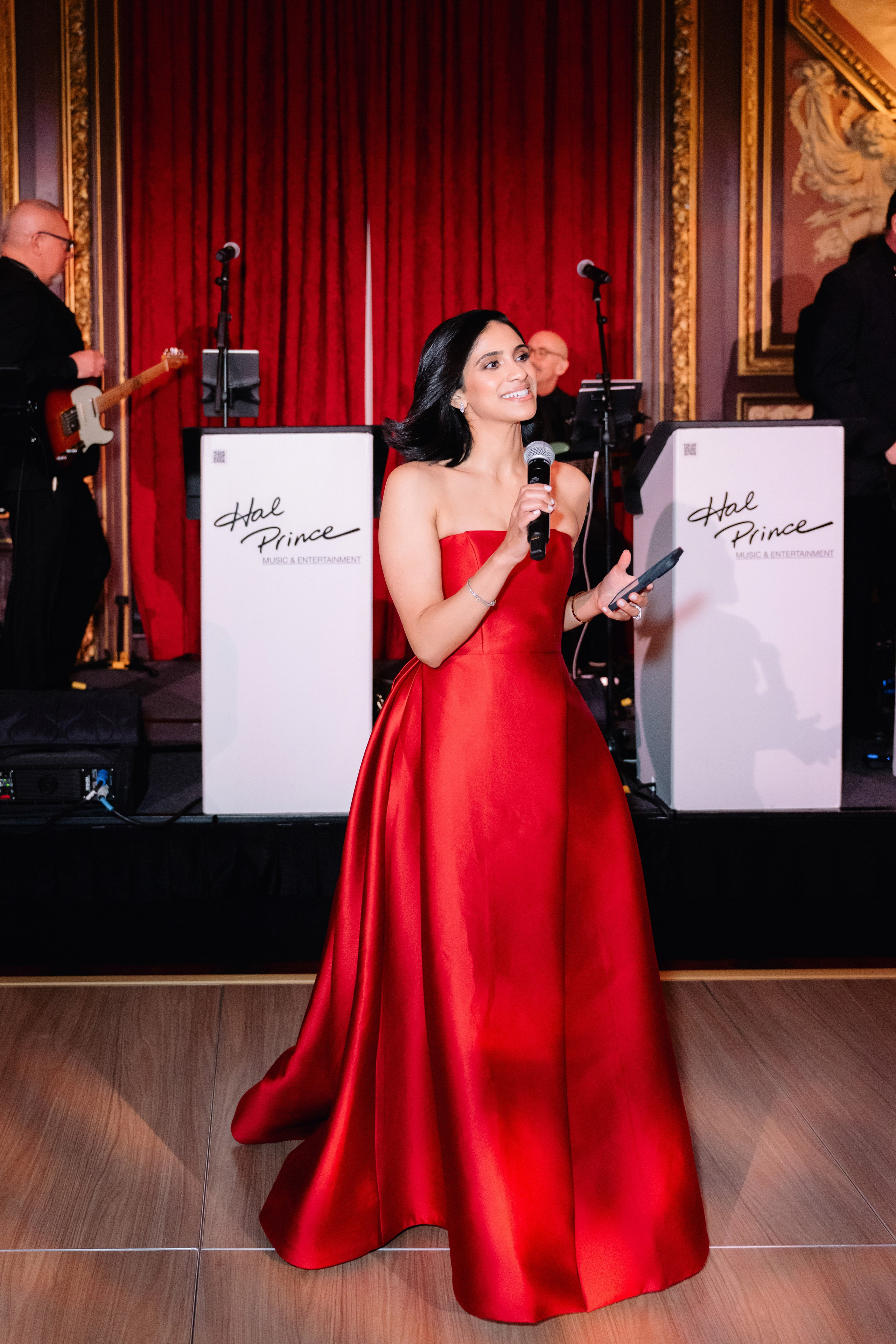 a woman in a red dress standing on a wooden floor