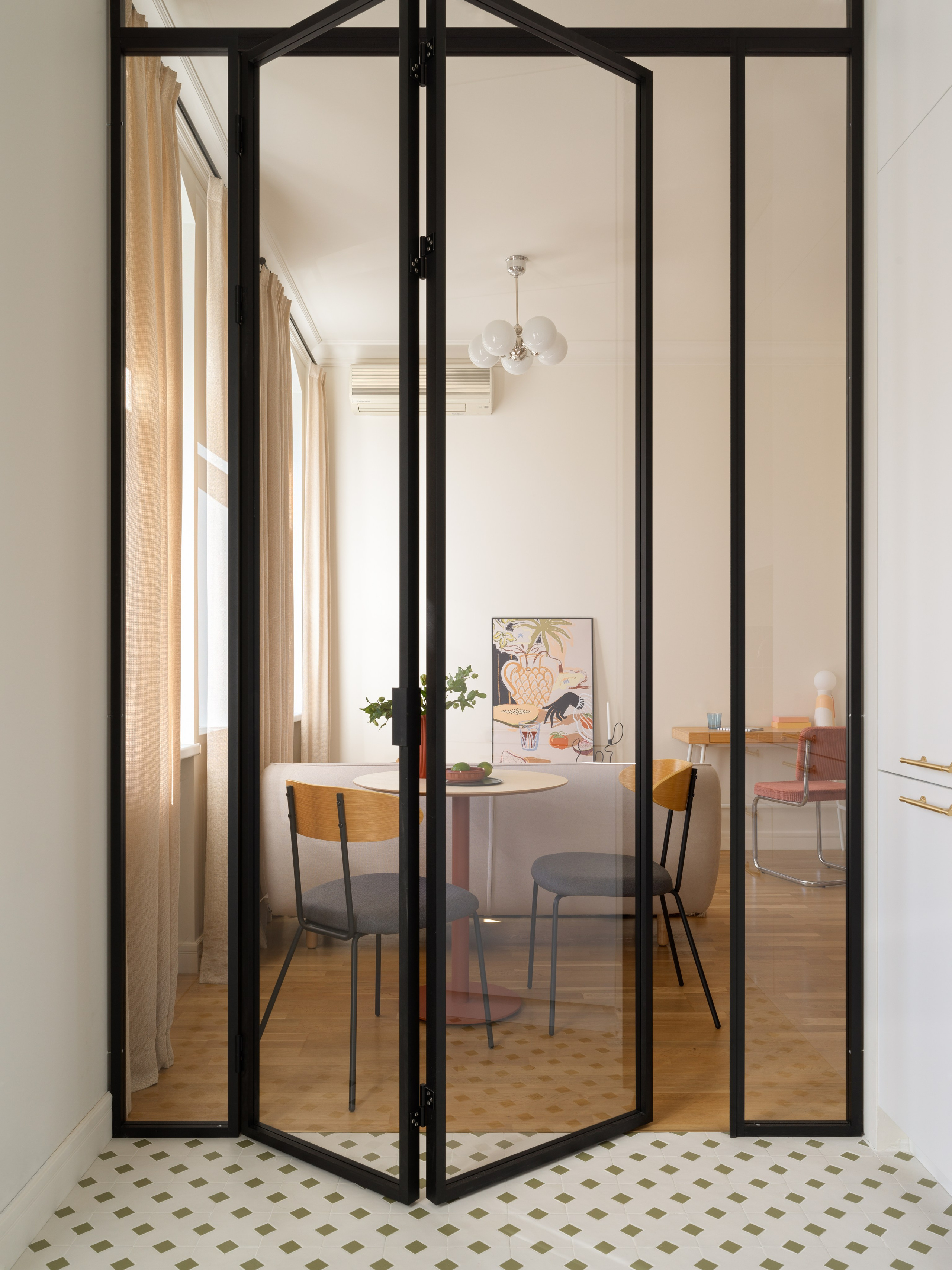 Современная стеклянная перегородка гармошка между кухней и гостиной.