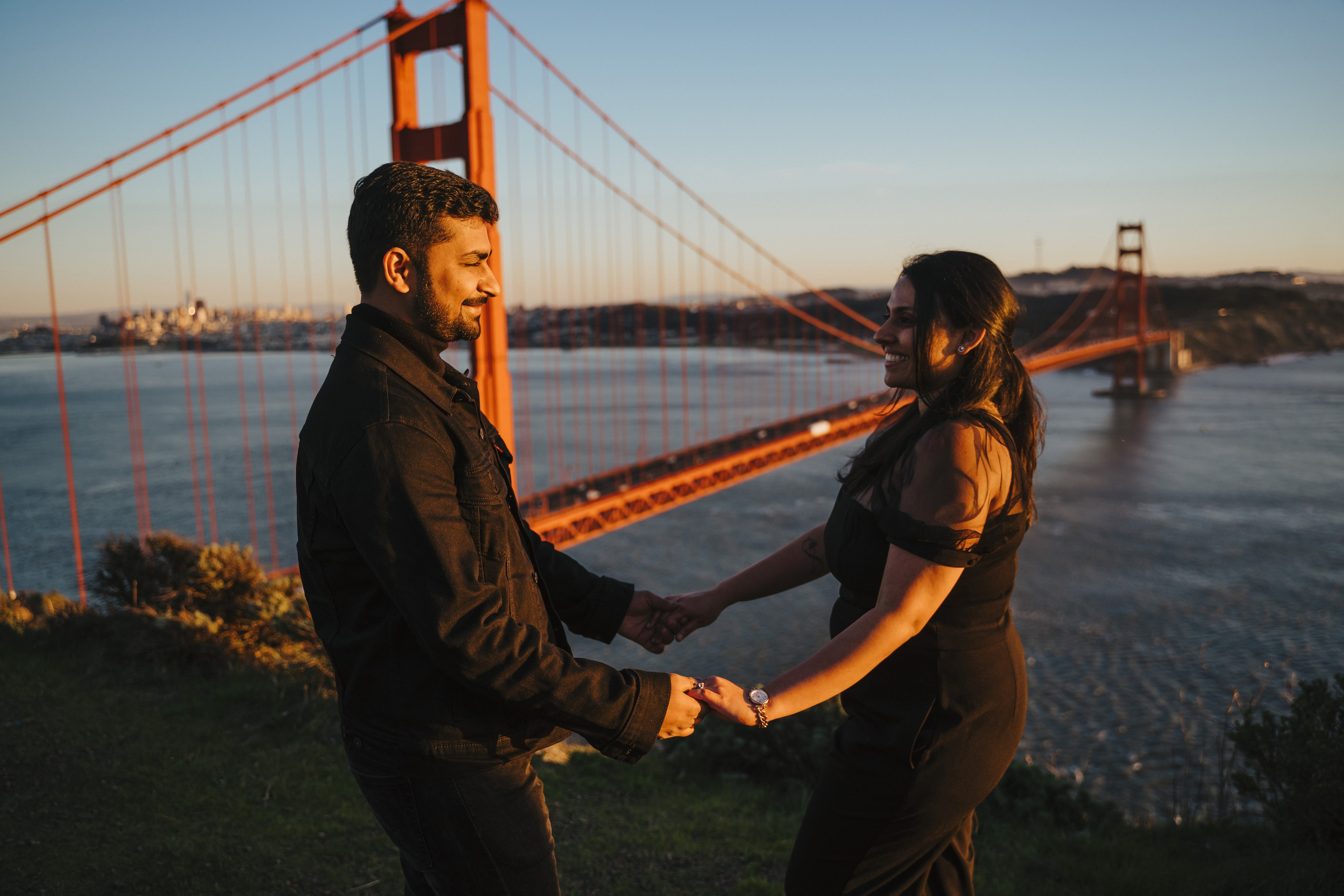Proposal.  Overlooking the golden San Franisco Bridge sunset with a couple. Photographer Video. 