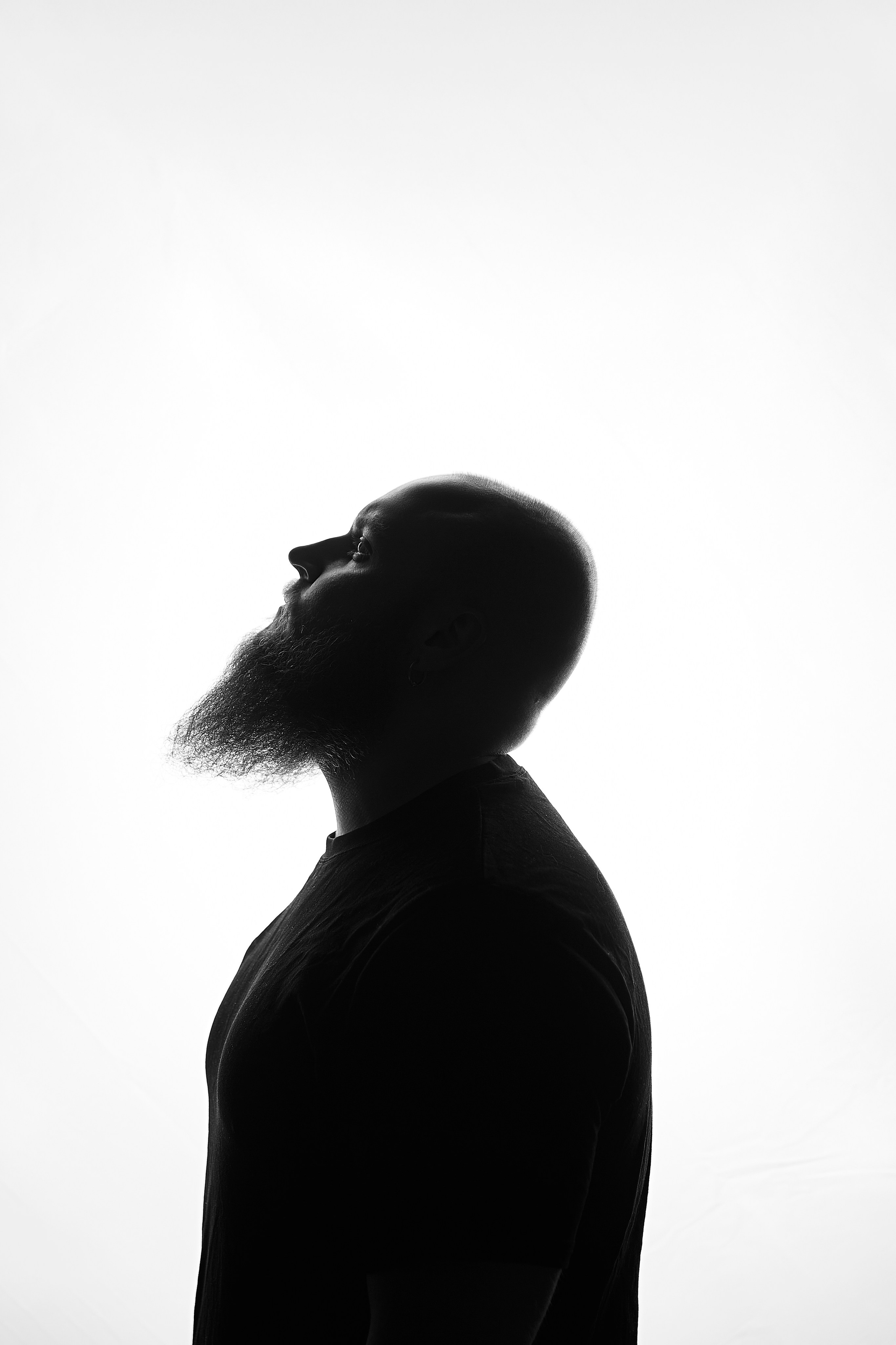 Силуэт брутального, лысого мужчины на белом фоне