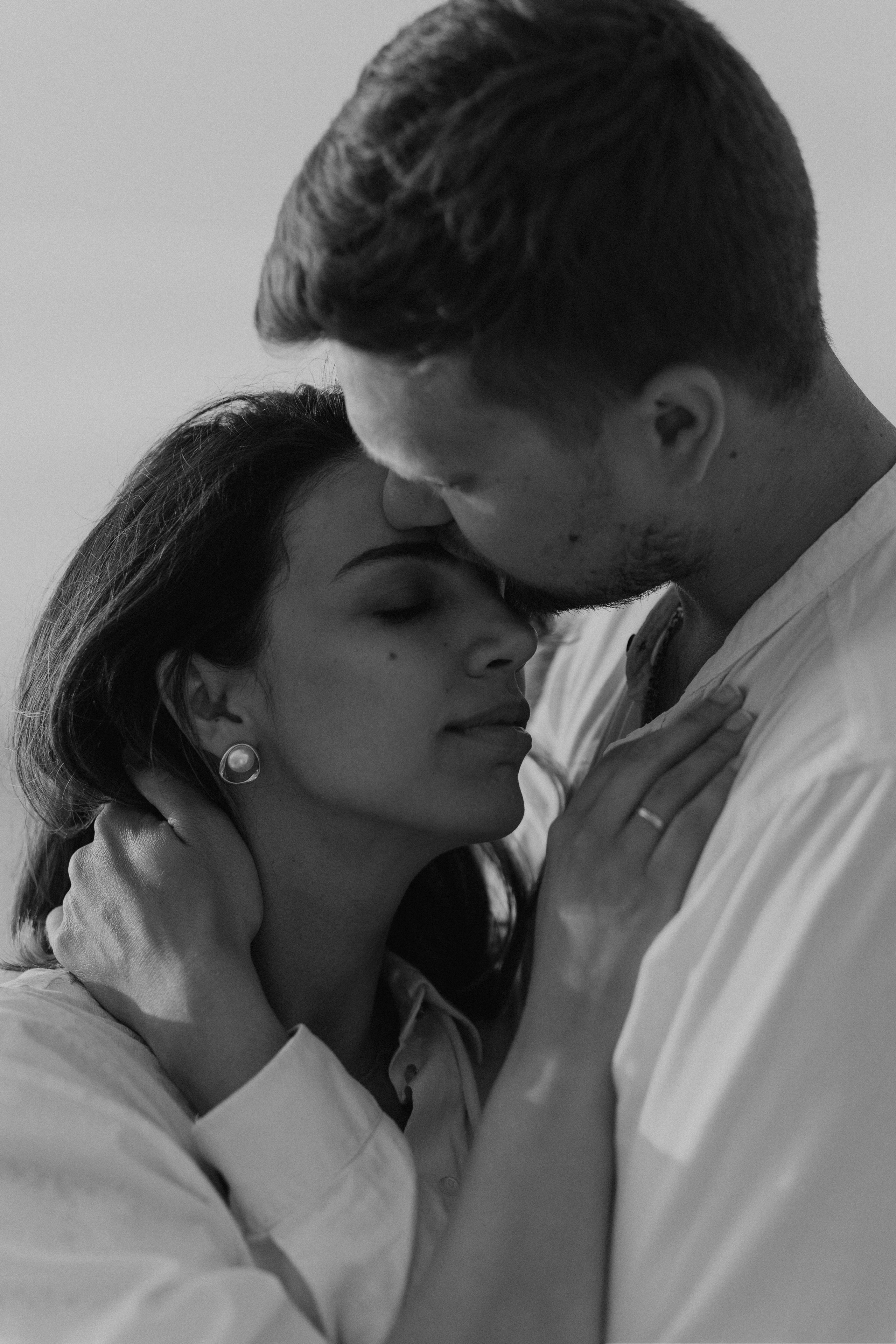 Dettaglio in bianco e nero di un bacio durante una love story