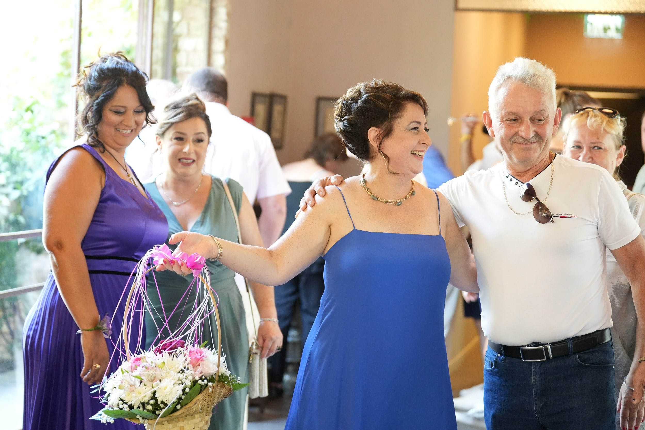 Wedding guests arrive with a flower basket and greet each other with an embrace