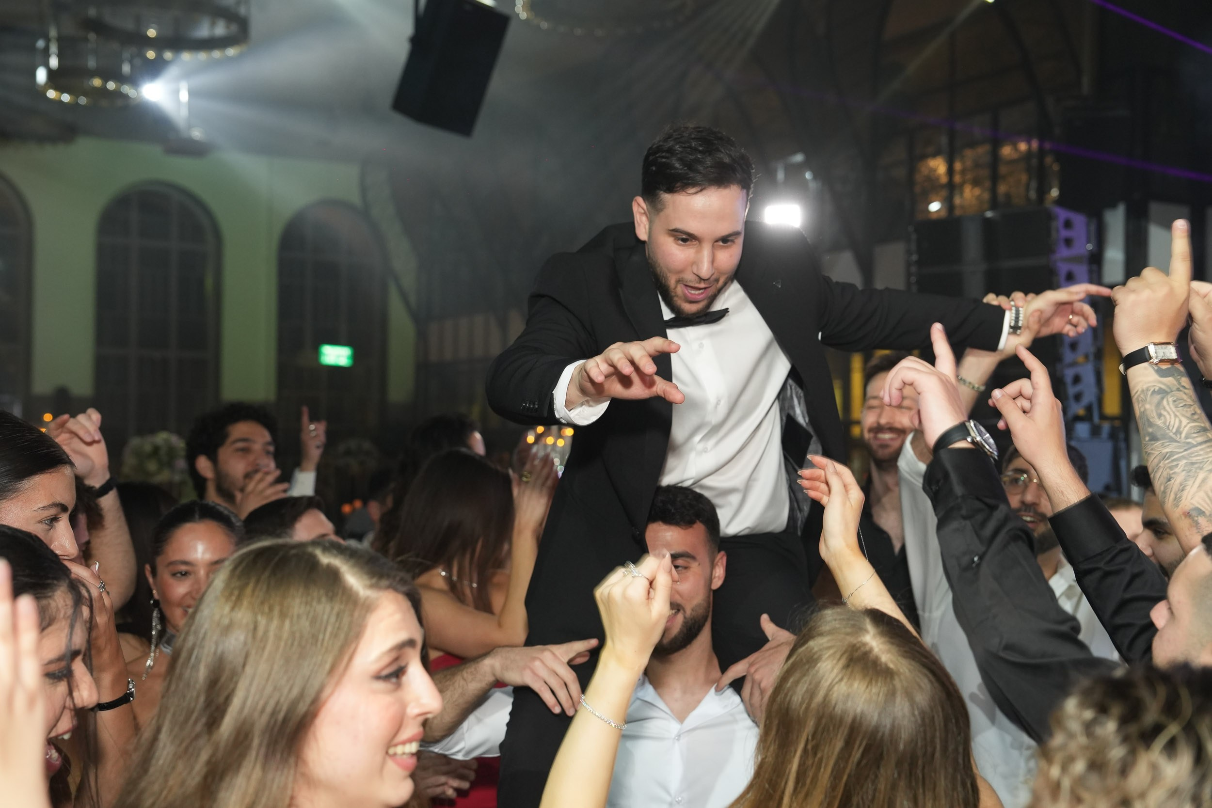 Groom Ron dancing on his friend's shoulders during the wedding party at 88 Event Garden in Emek Hefer, Israel