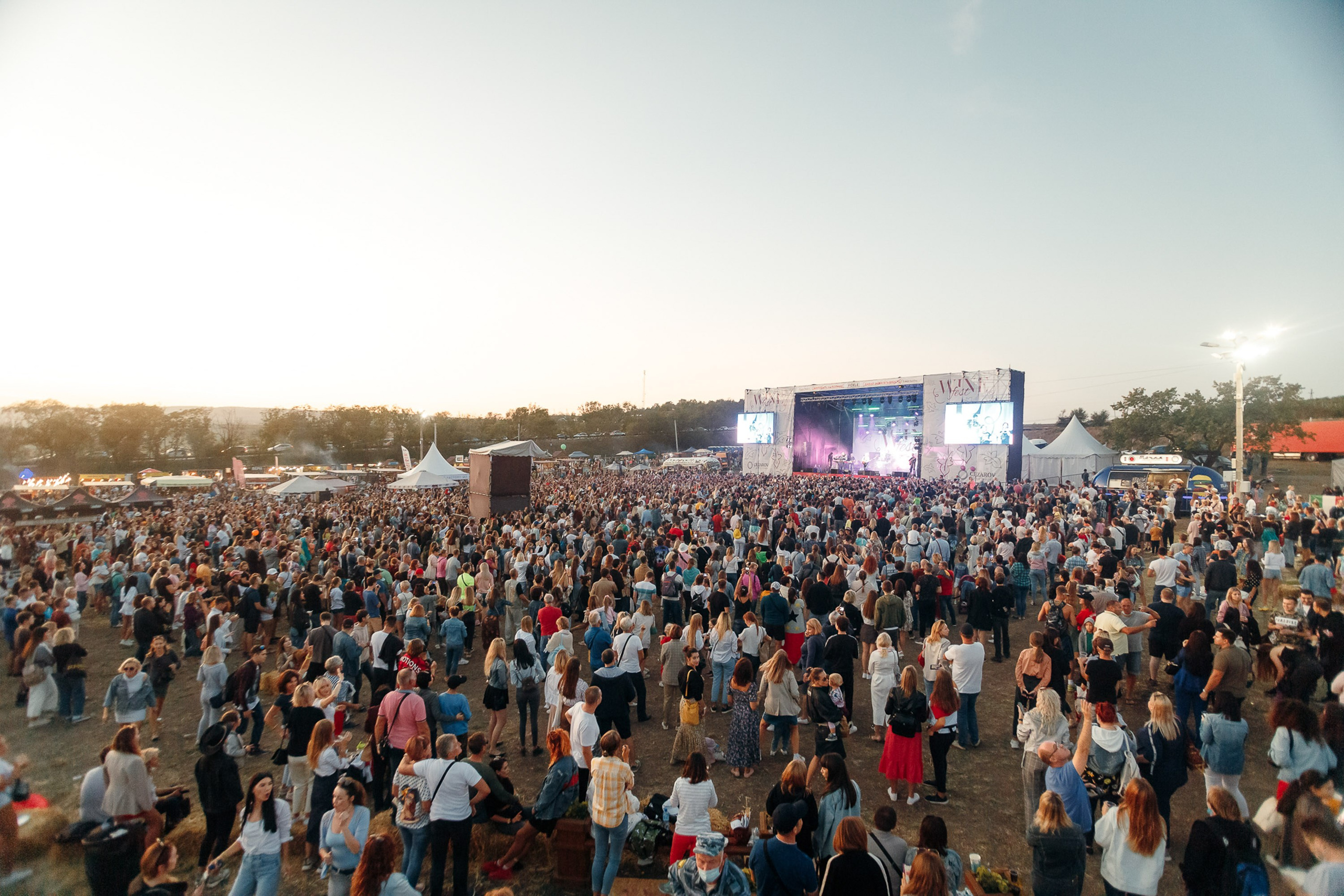 Large crowd at outdoor festival, daytime concert