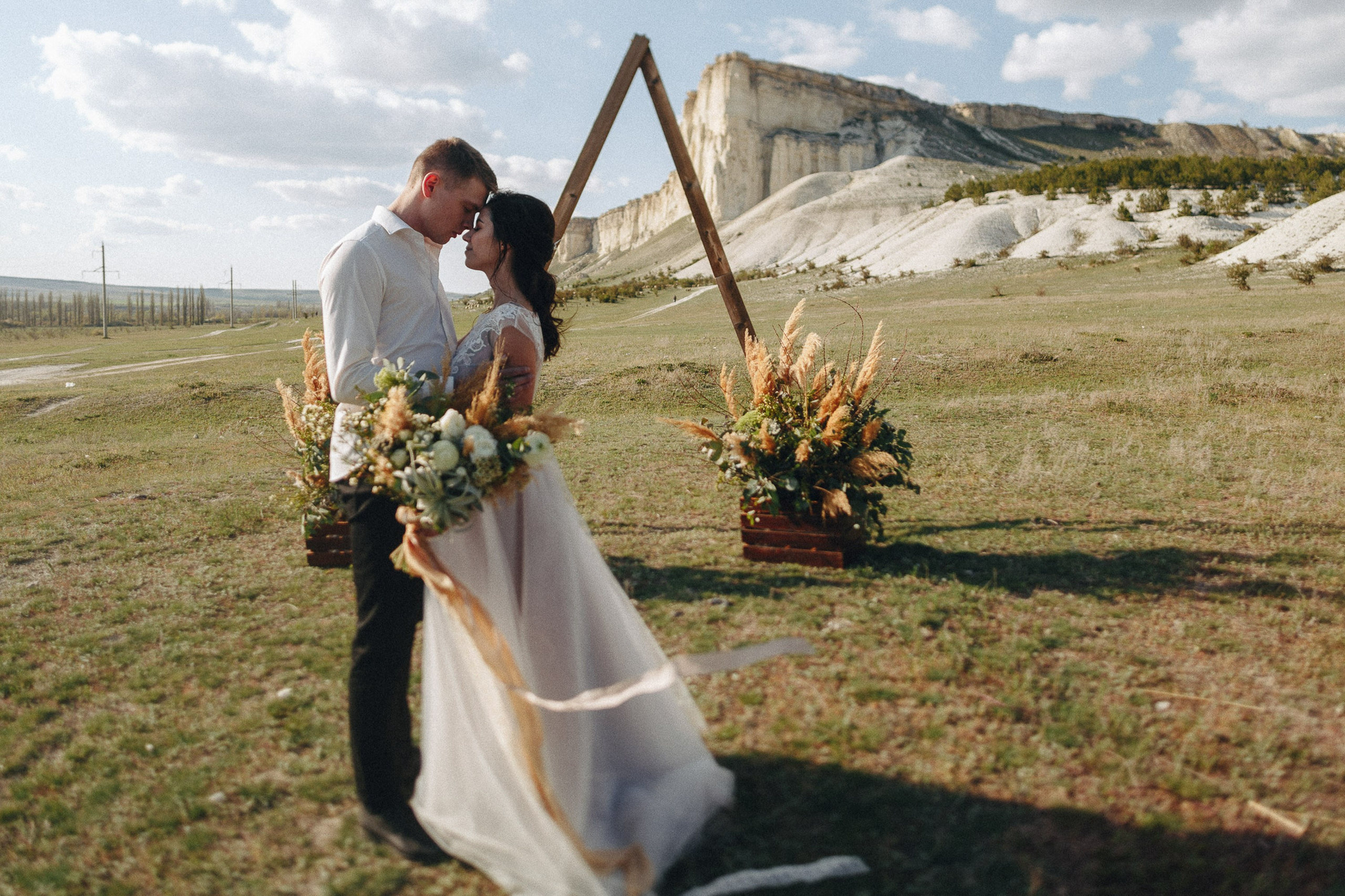 Bride and groom walking under wedding arch outdoors