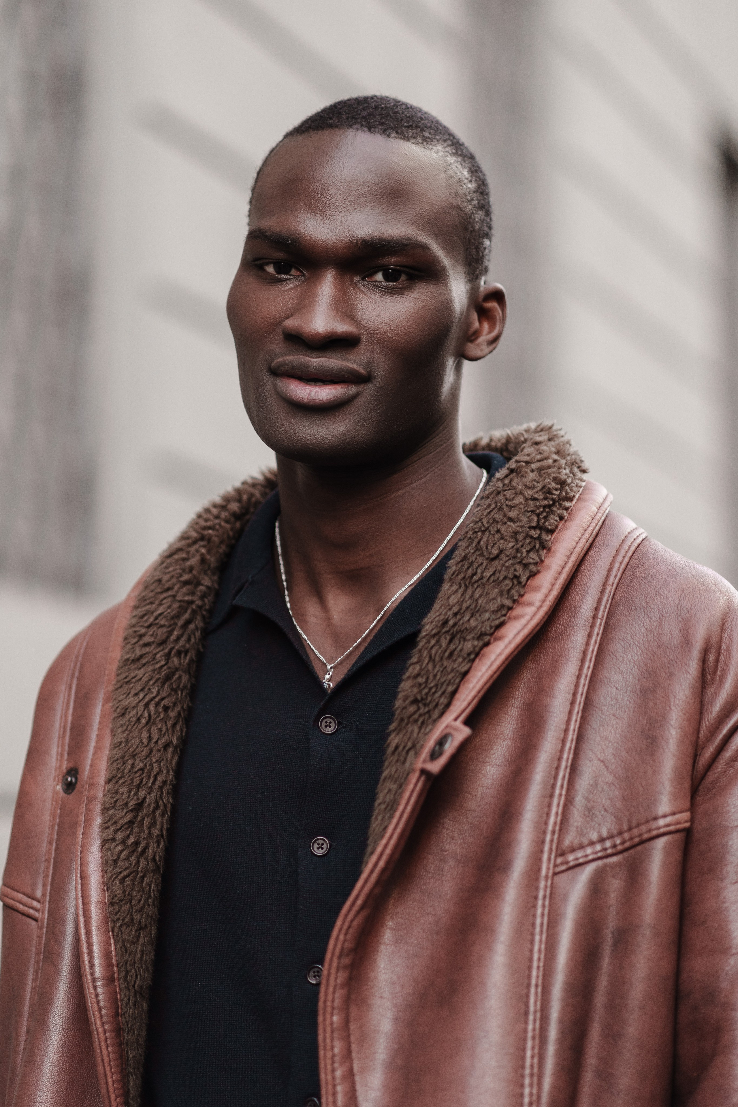 Model in a brown leather jacket exuding confidence at Milan Fashion Week, shot by a photographer in Milan.