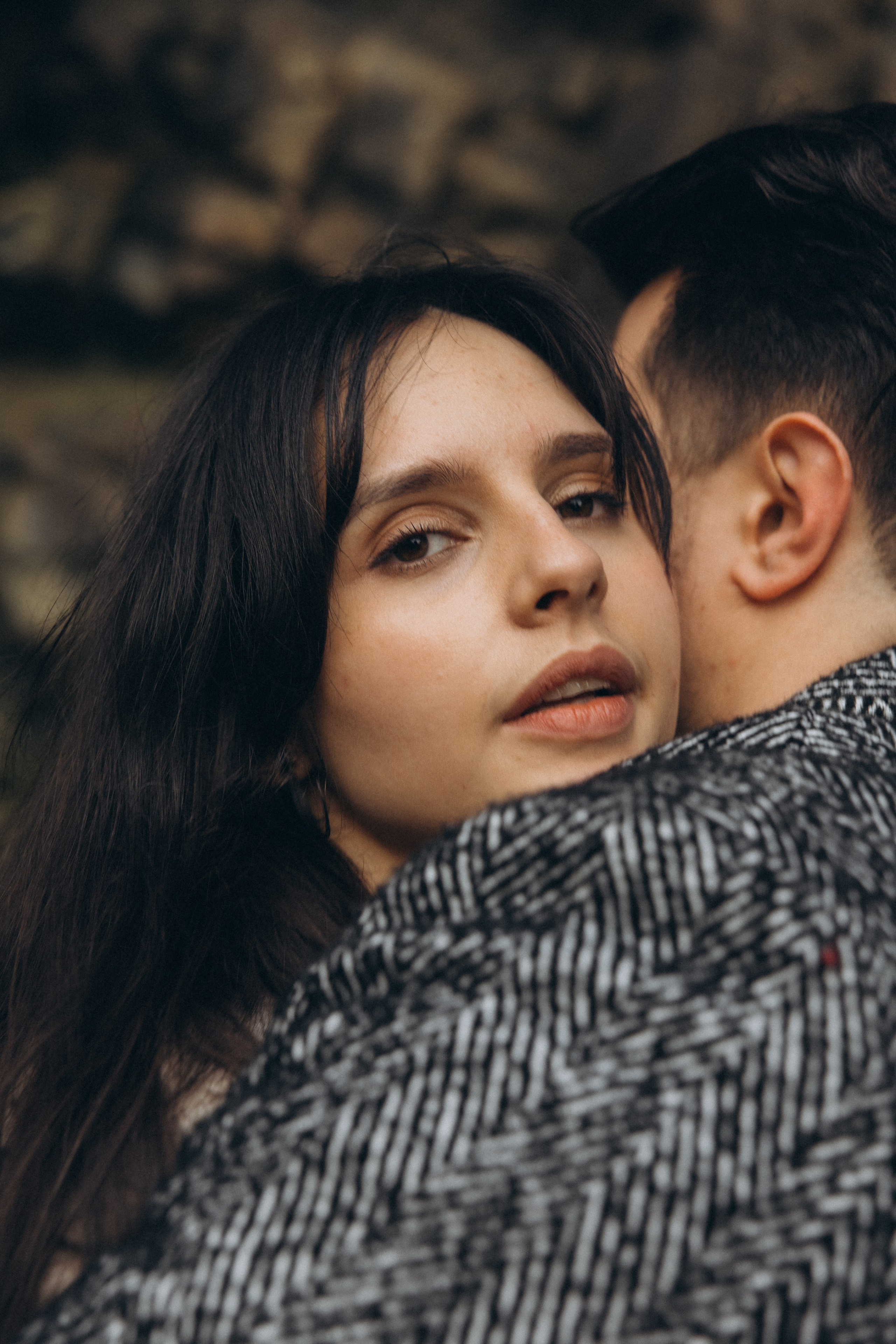 Couple holding hands and walking through a picturesque coastline in Portugal.