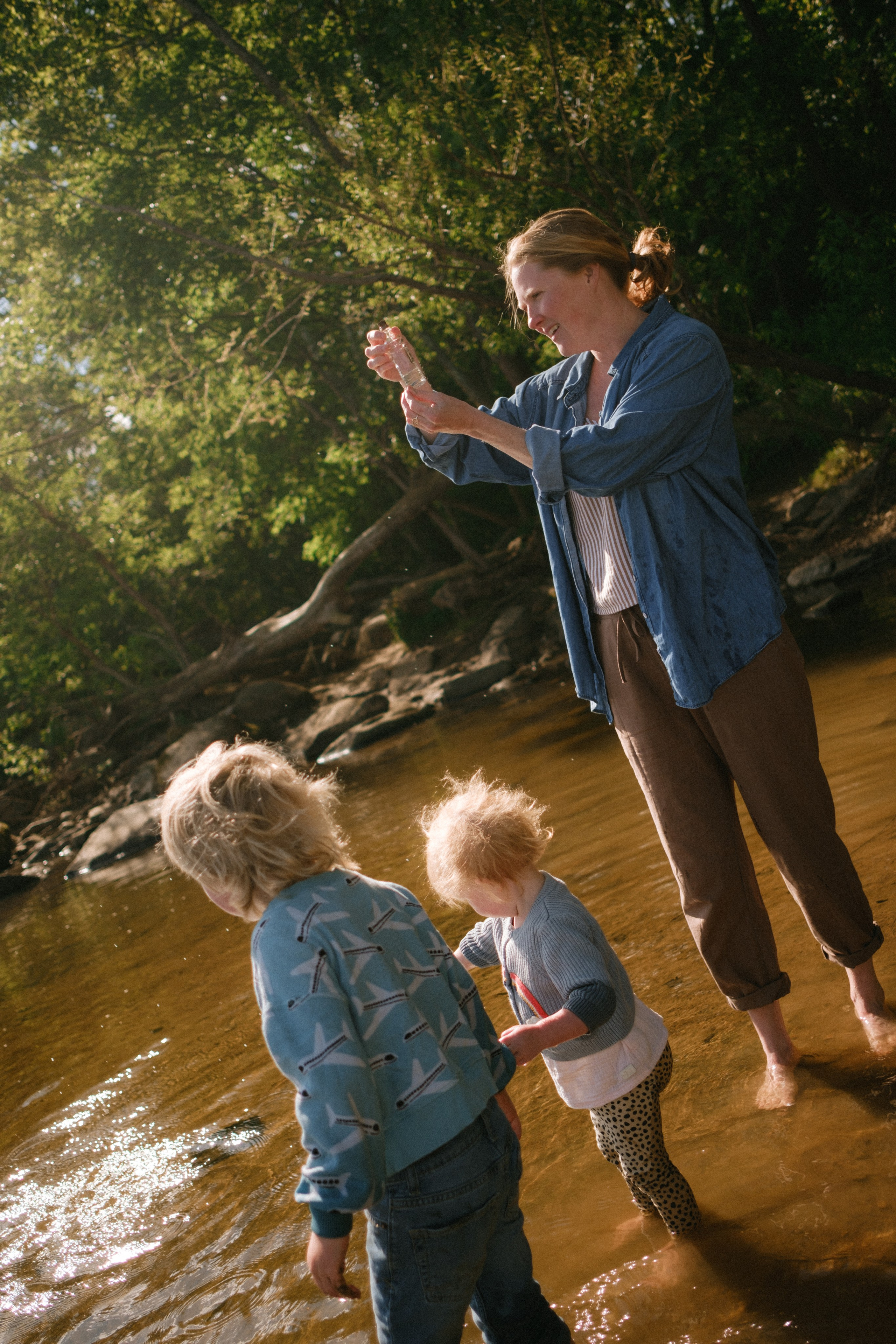 A fun, active lifestyle family photo session featuring a family walking barefoot through the shallow river rapids