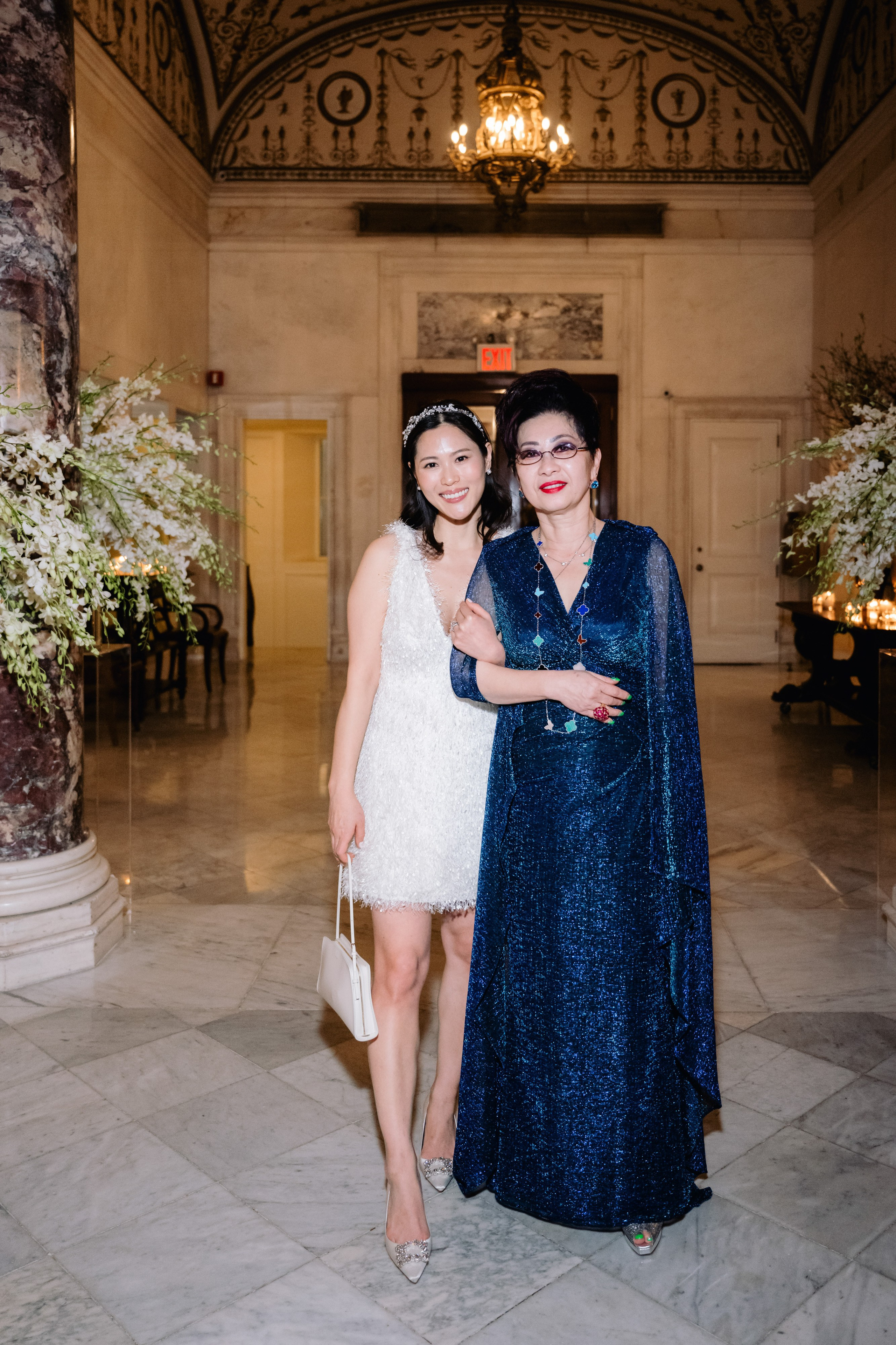 two women in formal dresses posing for a photo