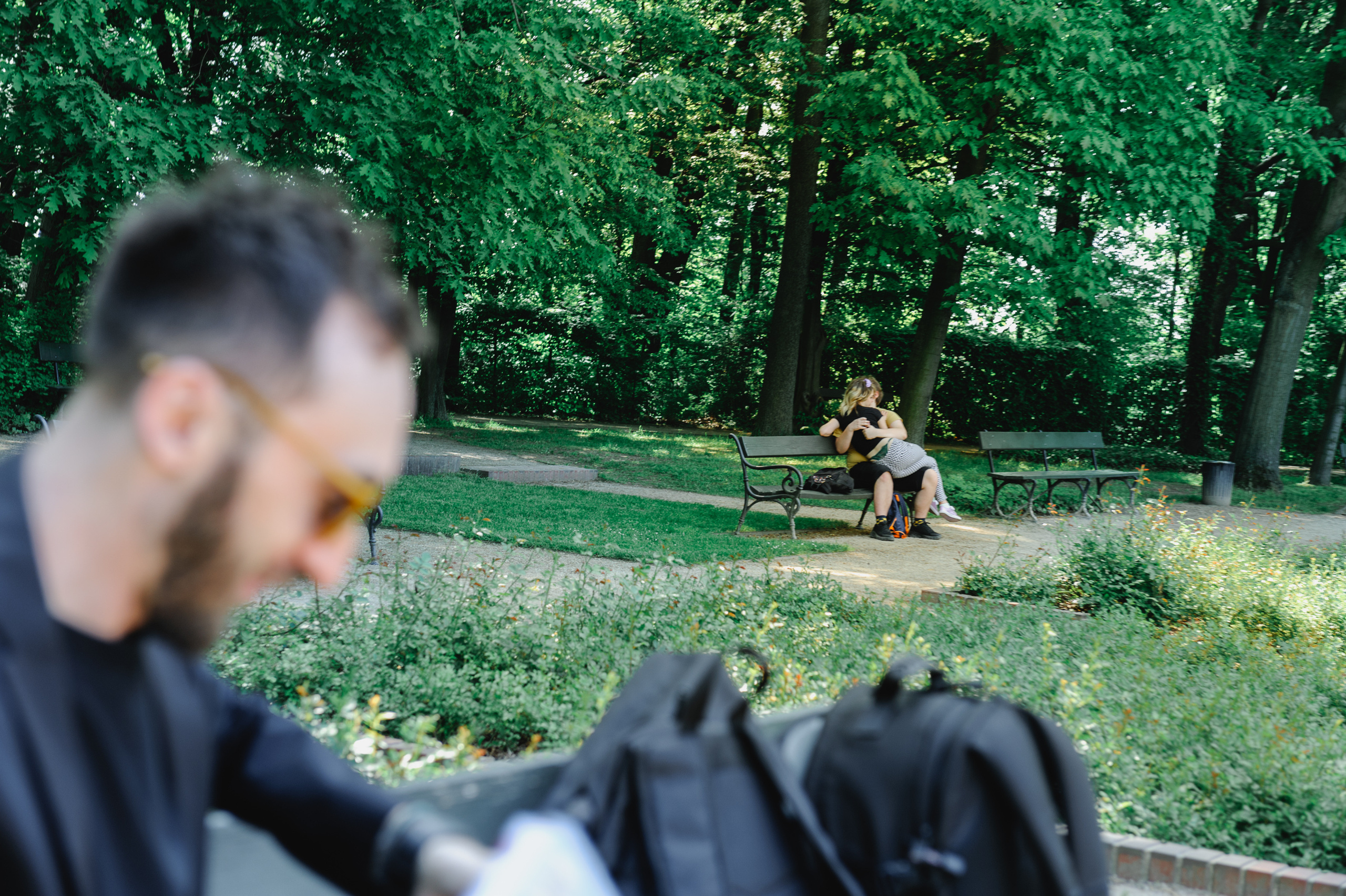 A couple in love hugging and kissing on a bench.