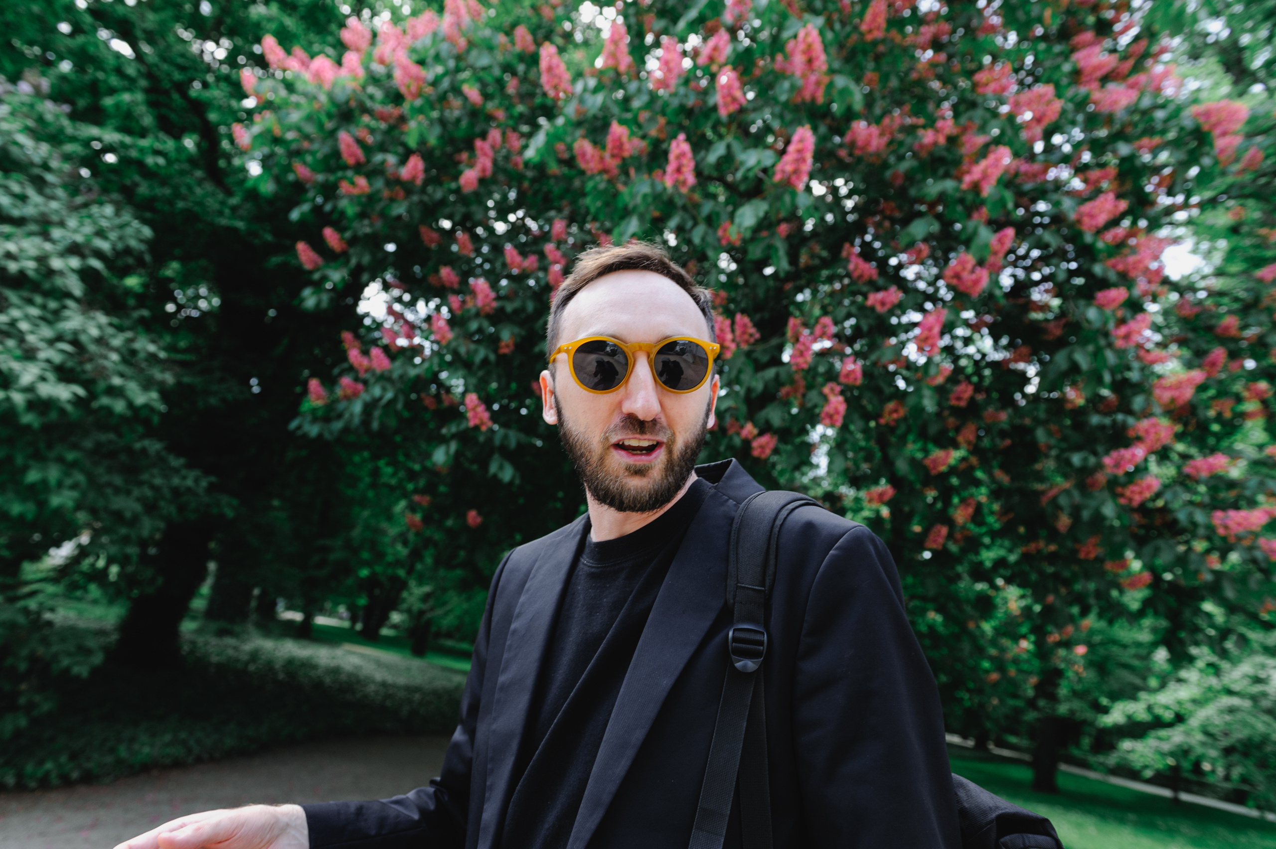 Cultural scholar Dmitry Solodkiy and a blooming red chestnut tree in the background.