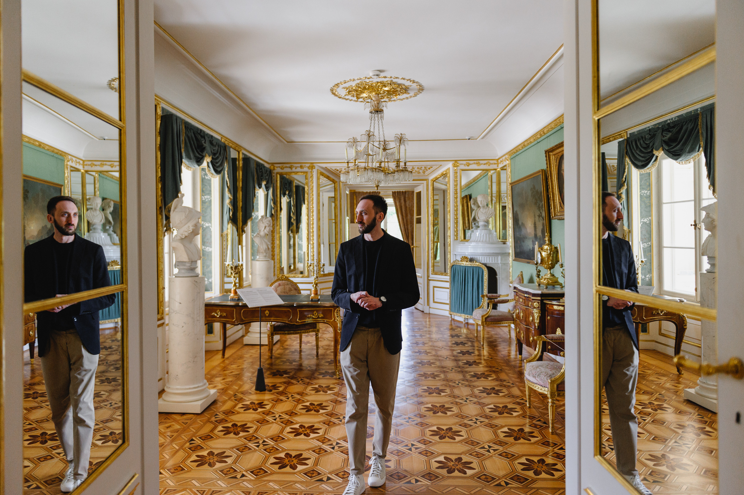 Dmitry Solodkiy is reflected in mirrors in a doorway passage. The Royal Baths Museum in Warsaw.