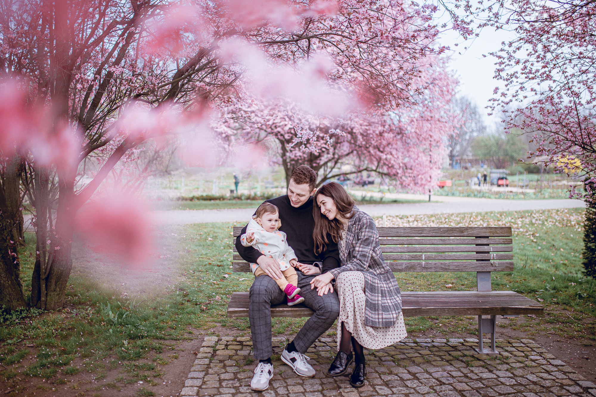 Familie sitzt unter dem Kirschbaum in Gärten der Welt