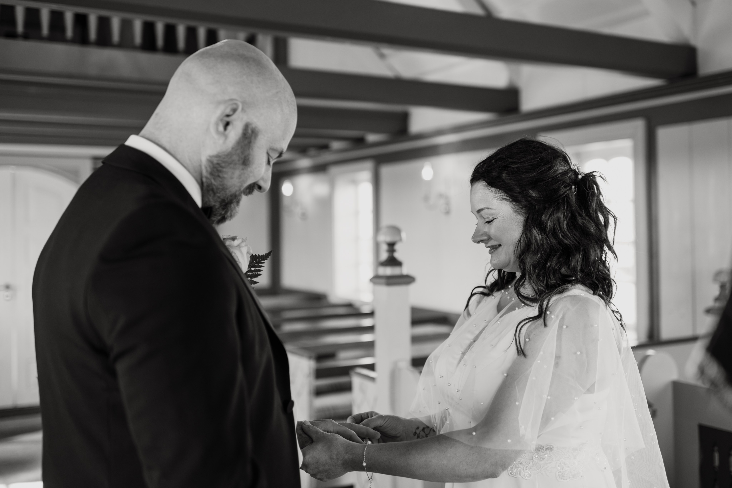 Newlyweds walking towards Búðakirkja, with the wild Icelandic coastline stretching behind them.
