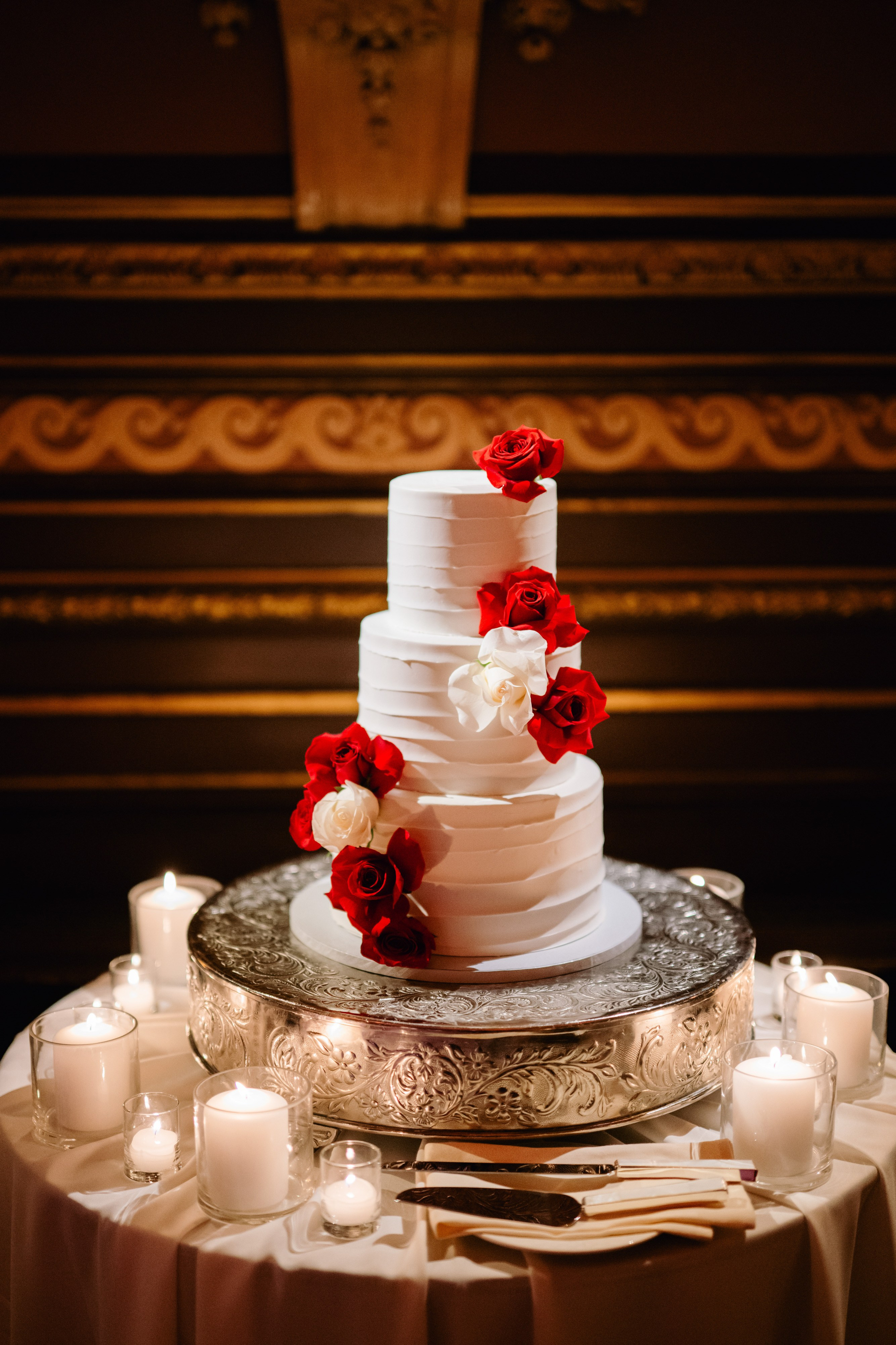 a white cake with red flowers on top