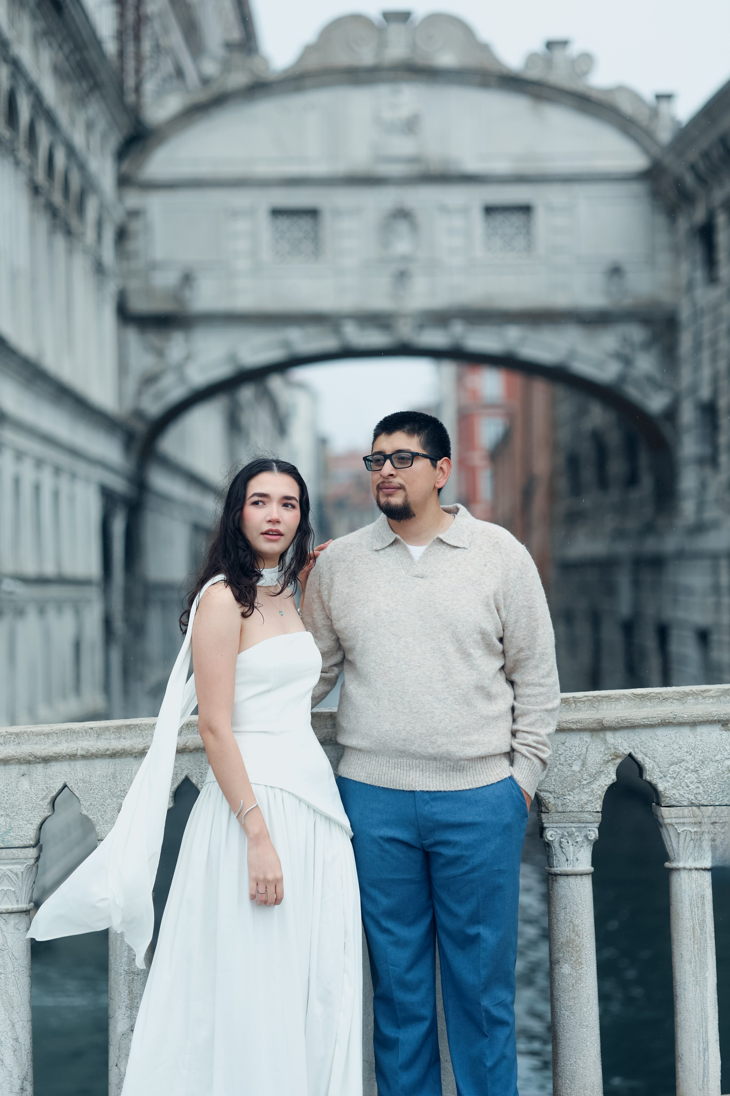 Romantic rainy-day couple photo in Venice, showcasing wet cobblestone streets, reflections, and intimate moments