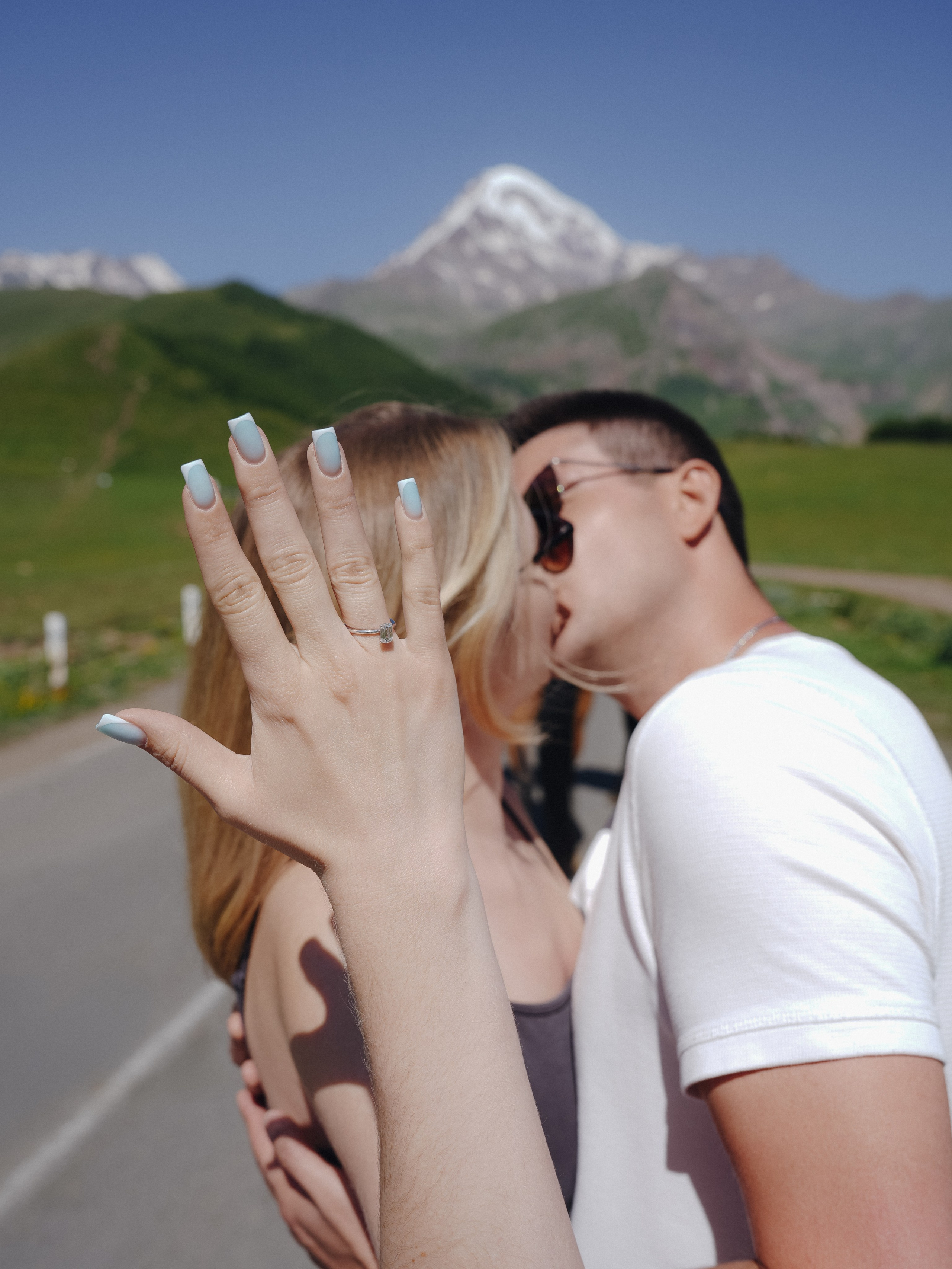 Close up kiss with engagement ring in mountains