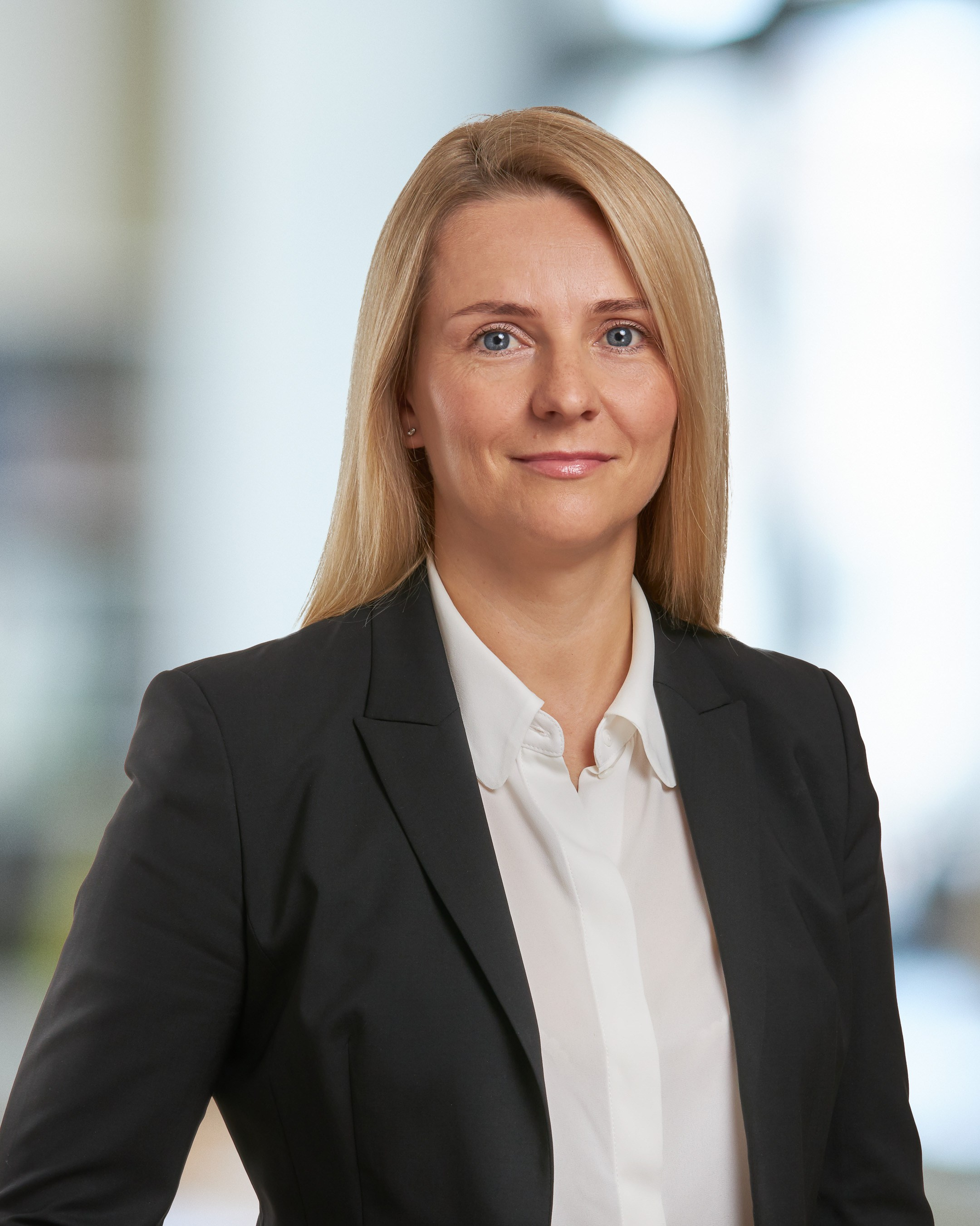 Business portrait of a young woman against a blurred office background - photographer Andrey Dunin
